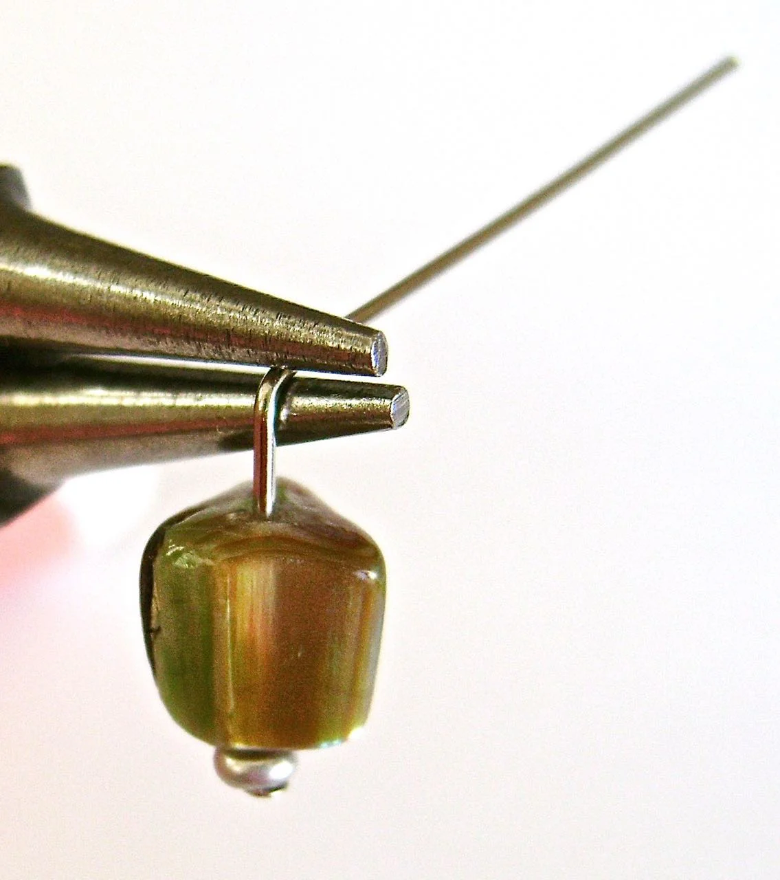 step 3 - With round nose pliers, grasp the wire inside the angle.
