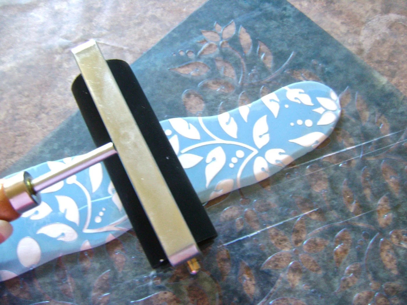 step 2 - Place the leaf stencil on top of the clay and roll across it until a good impression is made. Remove the stencil.