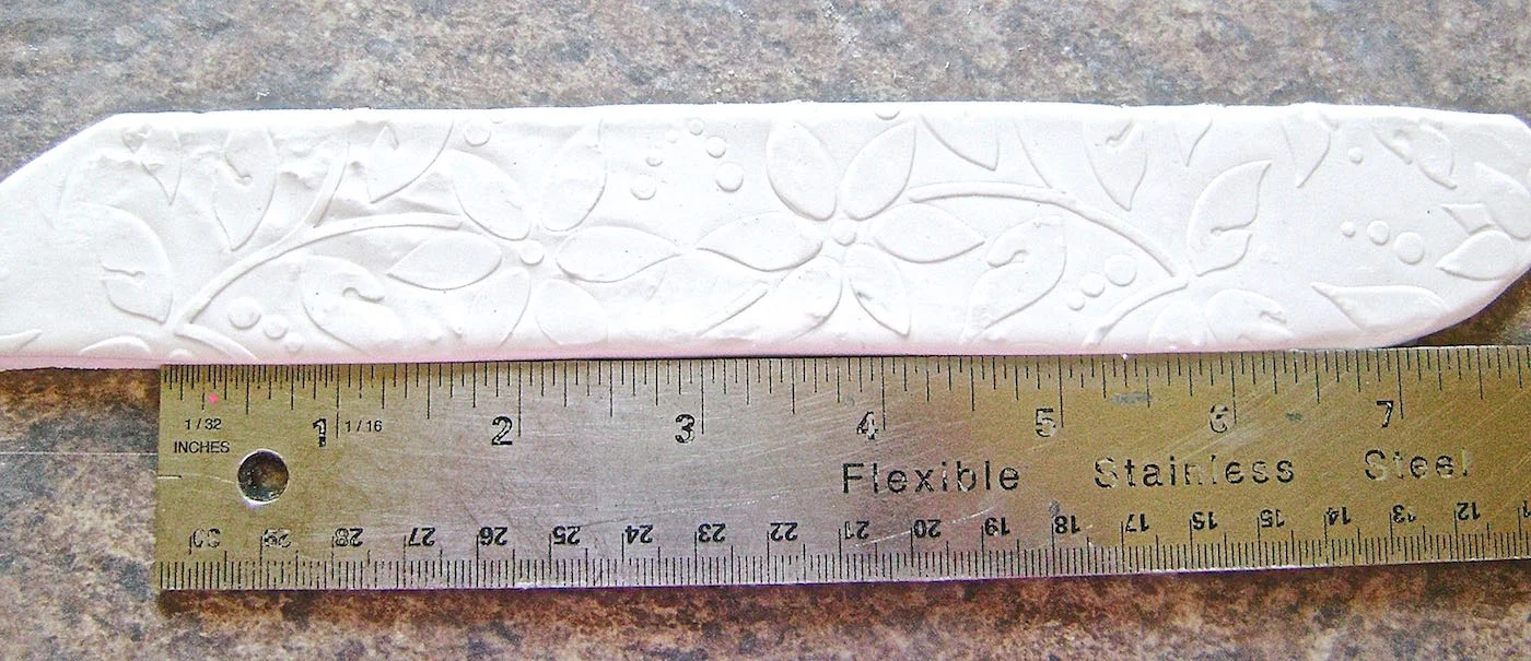 step 3 - Use a tissue blade or the sharp edge of a metal ruler to make a clean slice into the long edges, cutting away excess and leaving a 1.5” strip.