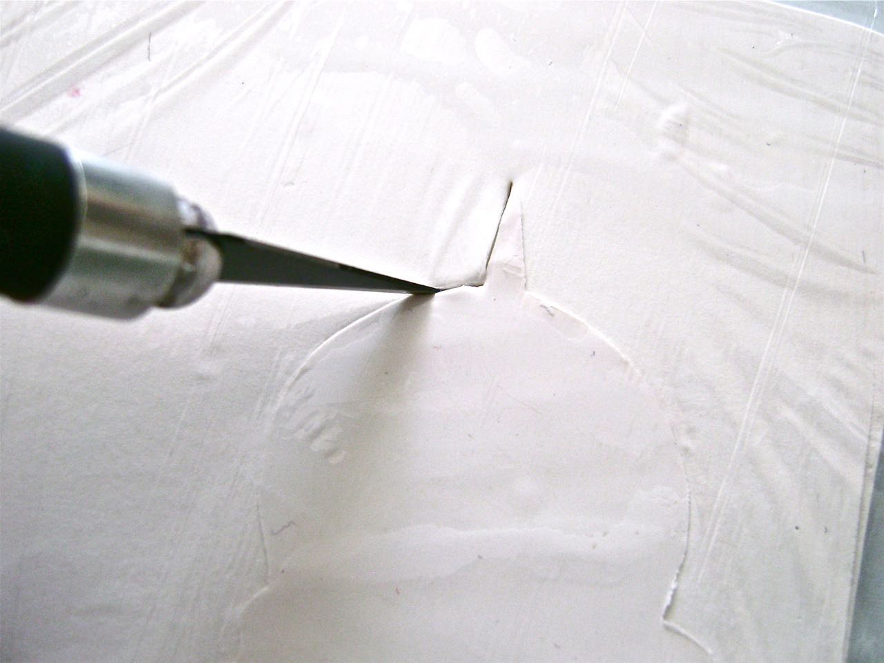 step 2 - Cover the clay with kitchen plastic wrap. Use a sharp craft knife to cut out the image. Remove the plastic.