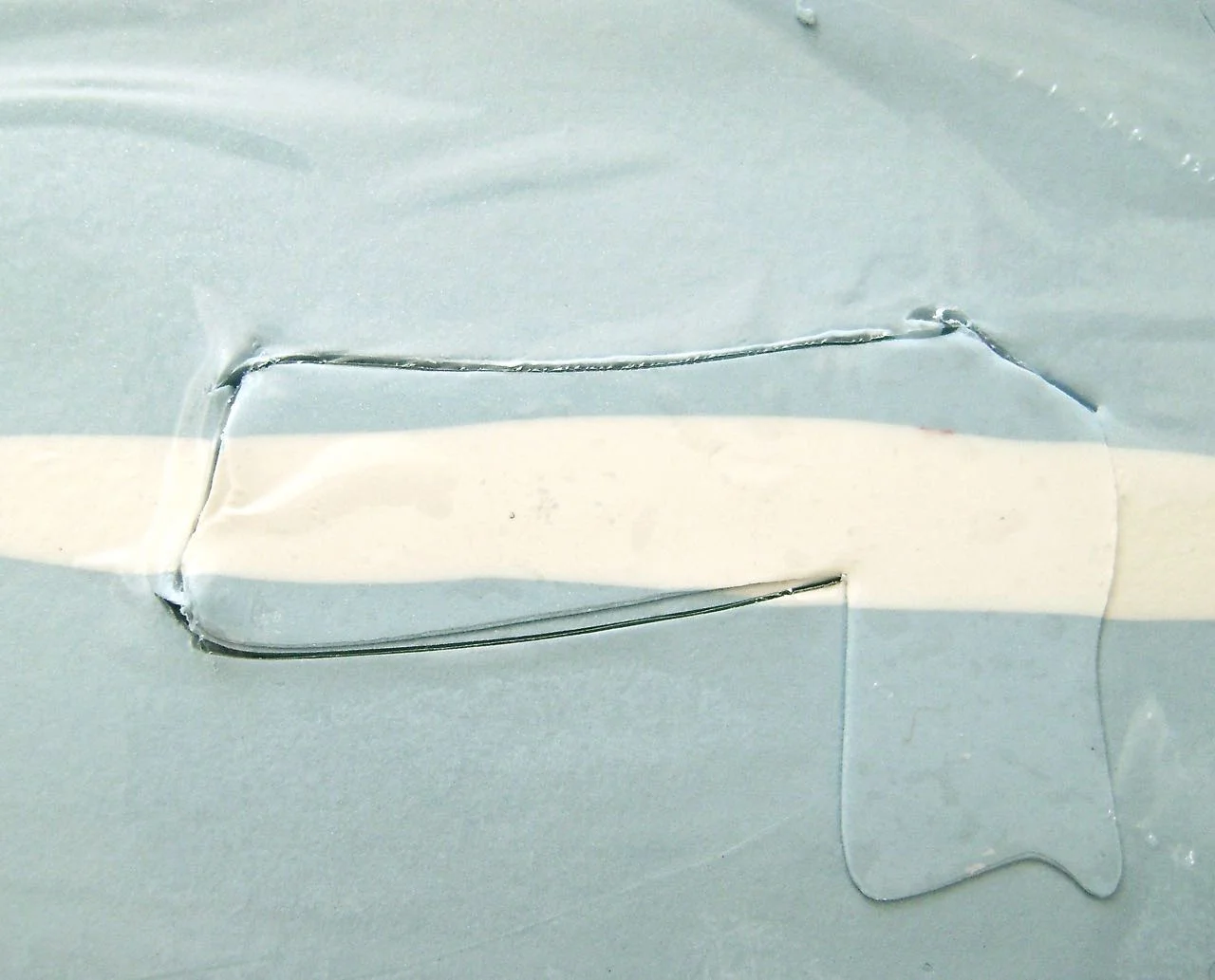 step 4 - Roll across the scarf template to leave its impression in the clay. Cover the clay with plastic wrap and cut out the scarf with the craft knife. Remove the plastic.