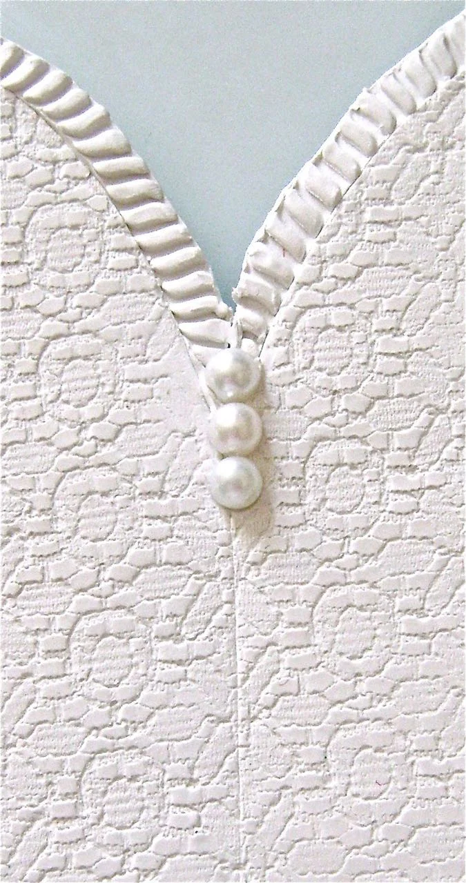 step 12 - Press the trim to the top of the heart shape and along the bottom edge. The trim should not overlap but rather butt up against the clay. Use a craft stick to push the trim against the clay without distorting the shape. Push three 6 mm pearls into the center of the sconce.