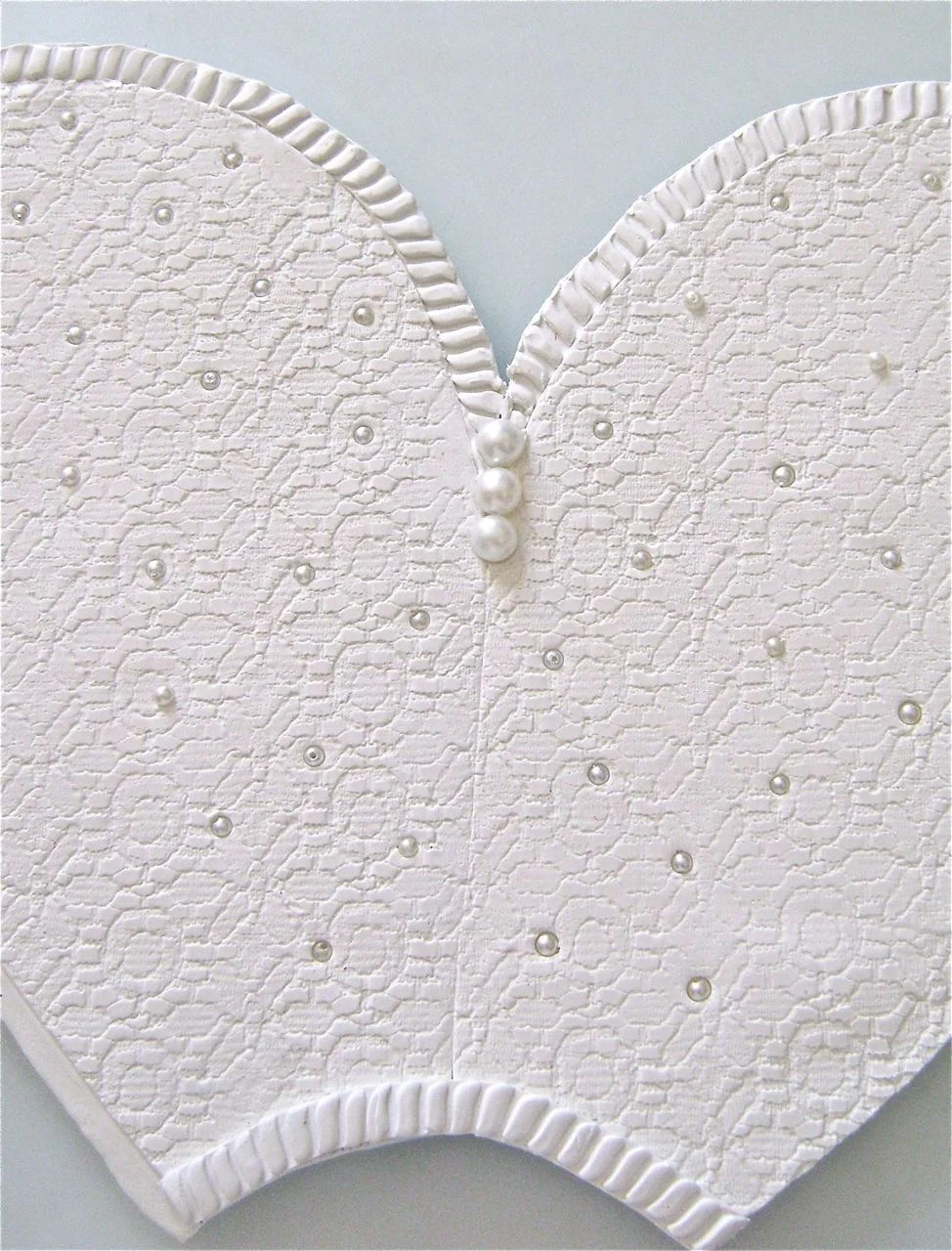 step 13 - Arrange seed pearls randomly on the front embossed areas. When you're certain of placement, push down on the beads with the flat wide edge of a ruler to evenly embed them into the clay.
