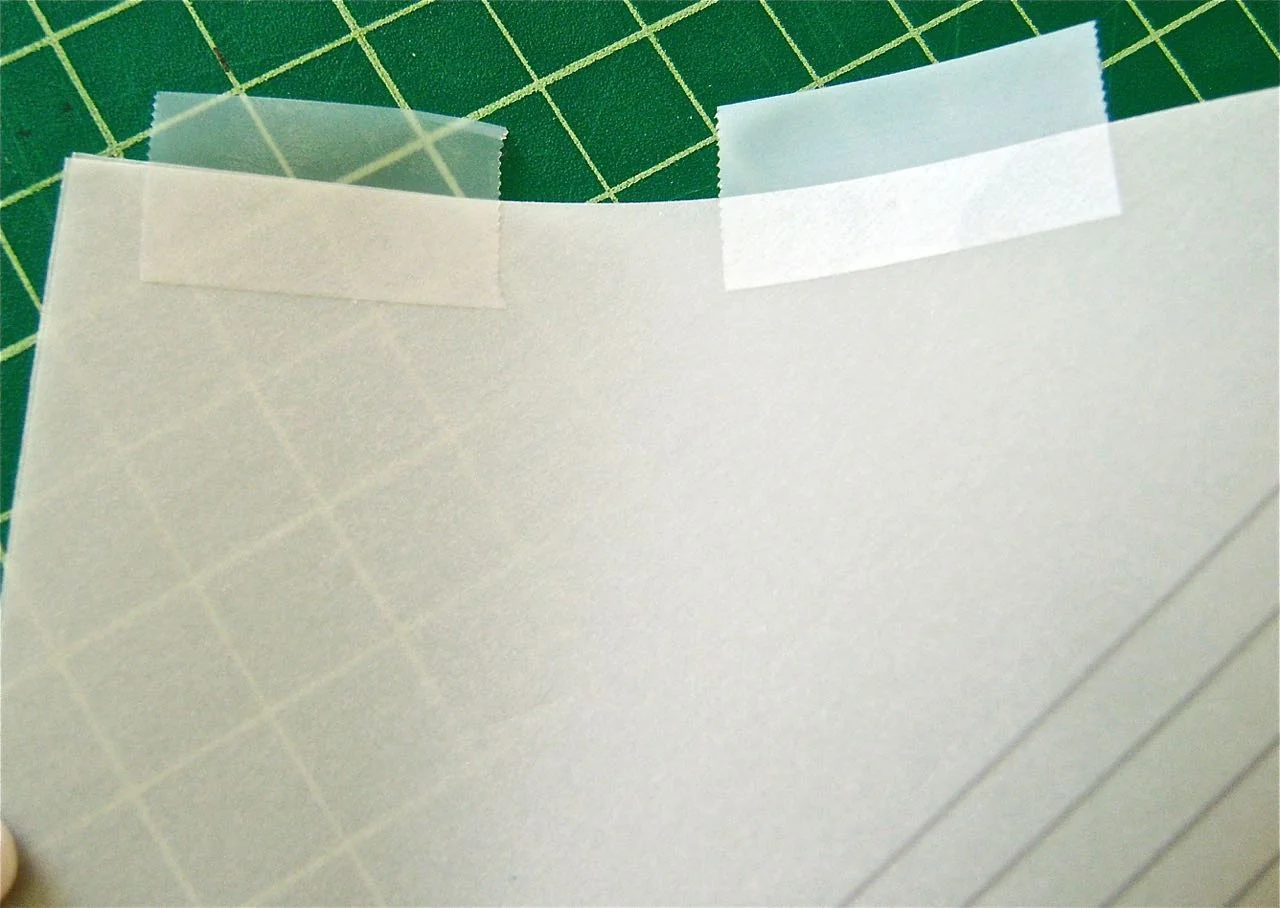 step 4 - Match the back edges and placetransparent tape along the length. Fold the tape over to adhere to the other edge. Set aside. 