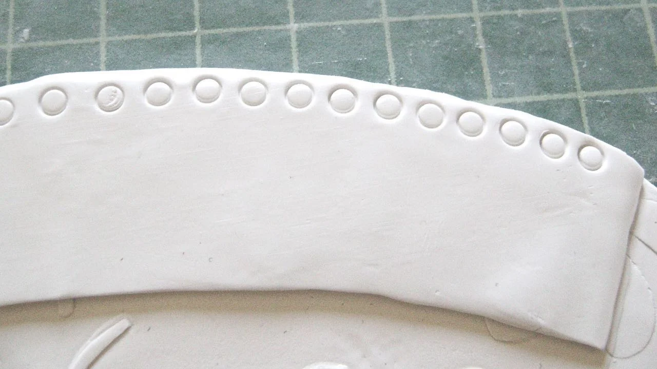 step 9 - Lightly touch the round end of an Etch n’ Pearl Tool to the border to make rows of circles which will be your guide for placing the rhinestones later.