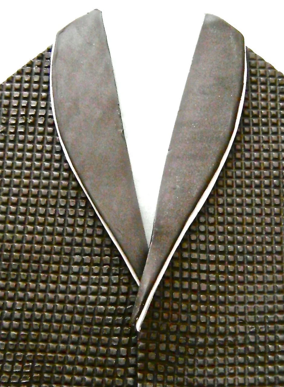 step 9 - Place the black lapel piece on top of the silver, allowing the silver to stick out and form a thin decorative edge. Align the lapels on top of the sconce pieces. Overlap the center fronts about 1/8”. Cut away the bottom left lapel where it meets the right to eliminate excess bulk of the combined pieces. Also press the length of the left center edge with a craft stick to thin it. Press to join the left and right pieces.