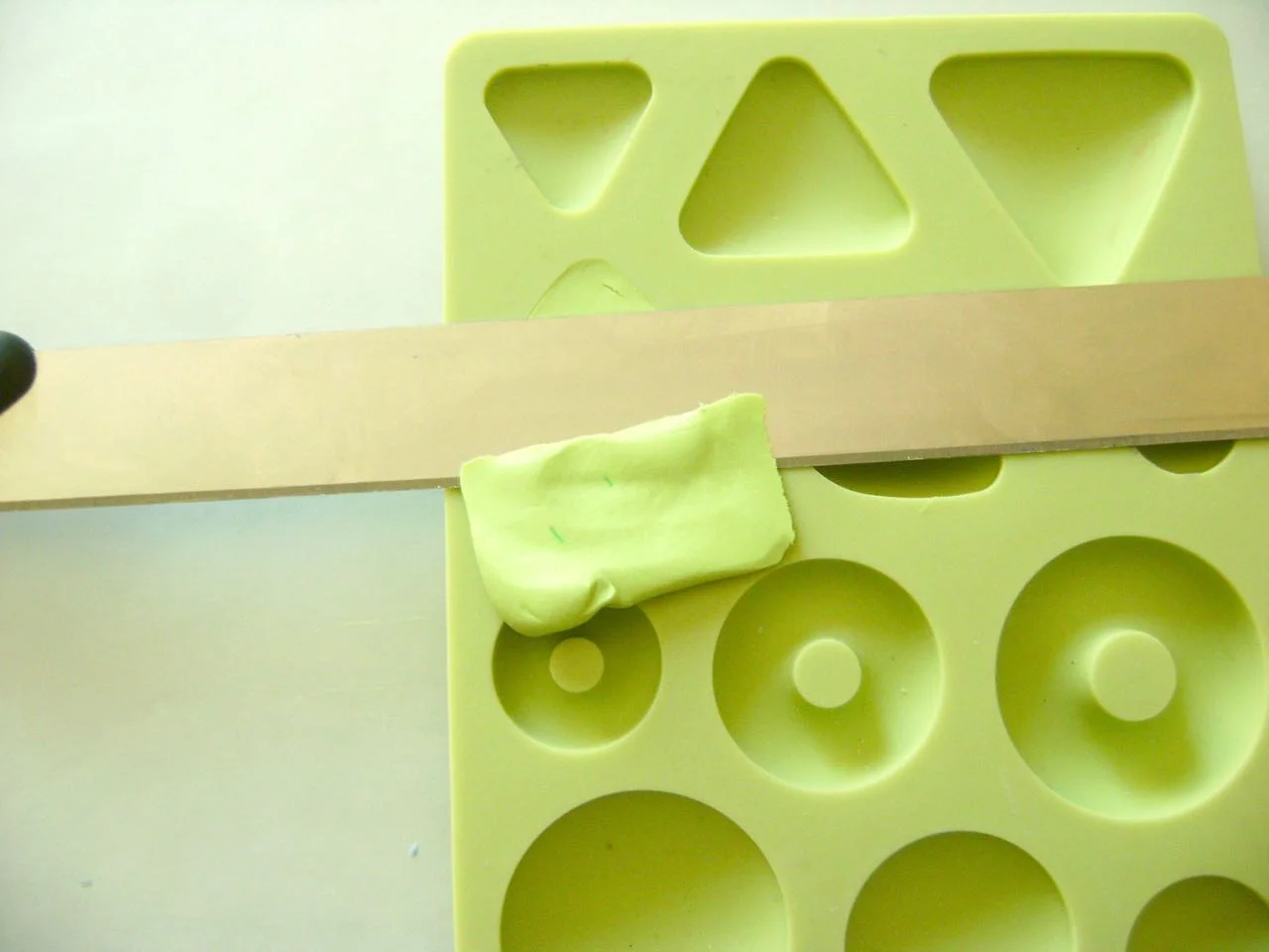 step 1 - Download and print the boot template on copy paper. Roll three strips of black and two strips of plum clay to the same length. Alternate the colors and twist them together. Flatten the piece and run it through the conditioning machine to blend the colors in interesting ways.