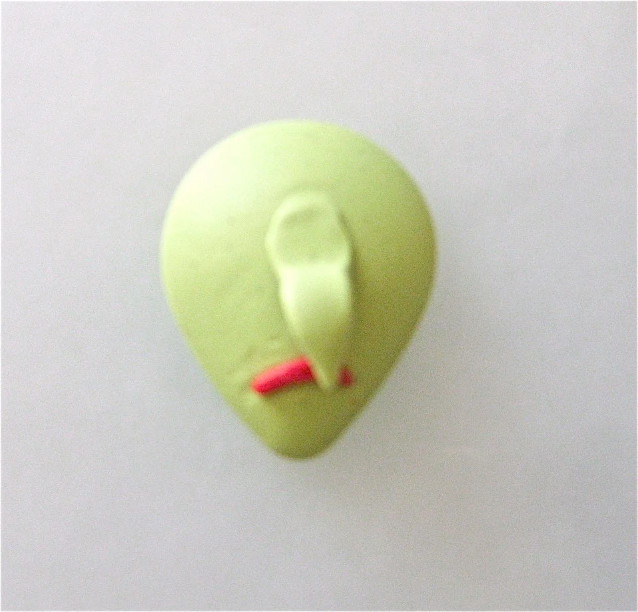 step 2 - Roll a bit of red and green clay for the mouth and the nose. Place them on the face. Don’t fuss with them too much now. You can perfect the shape as you work the other steps.