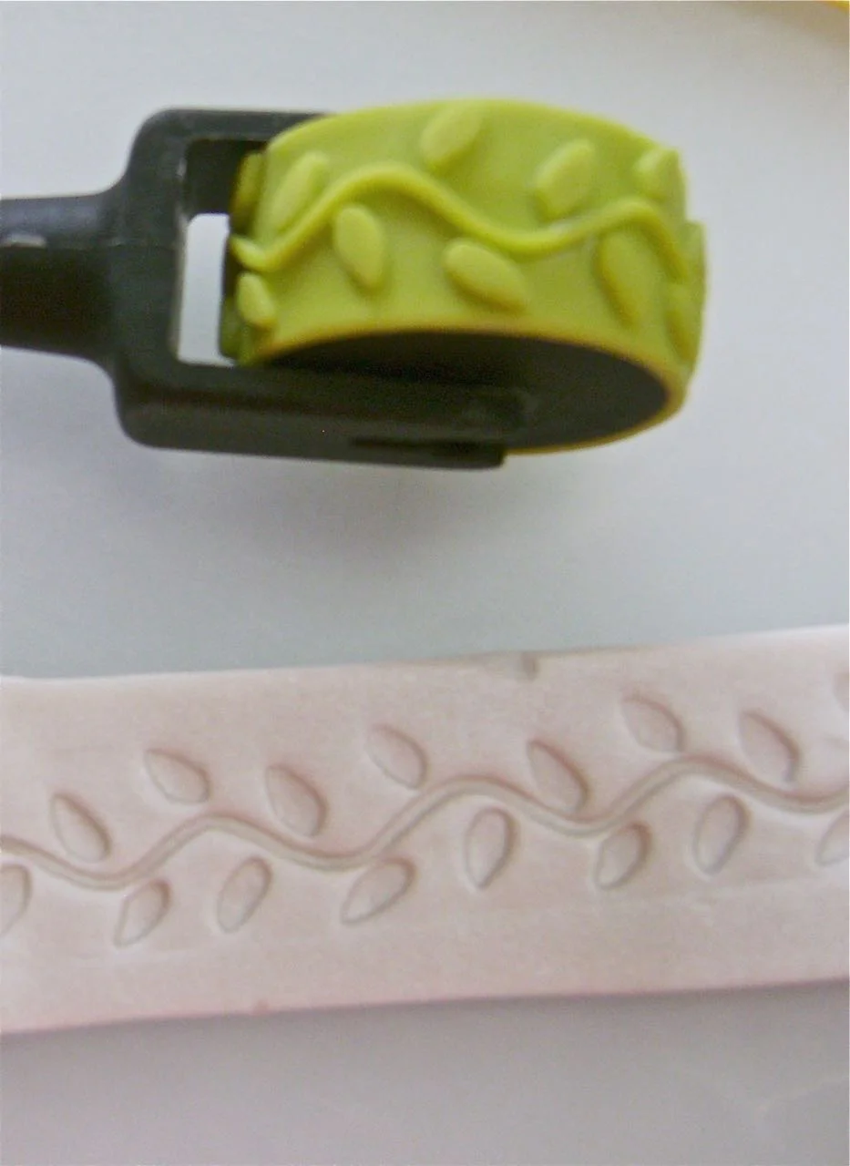 step 3 - Cut .50” Inch strips from Pearl clay and join them, blending the edges until you have a long enough strip to spiral around your mirror handle from top to bottom. Before you wrap the handle, roll across the long strip with the vine design texture wheel. 