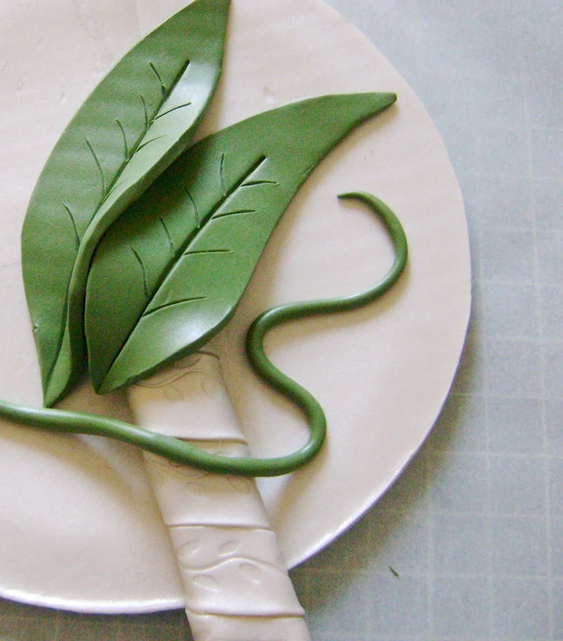 step 12 -Roll a strip of green clay to a thin tube to create a vine.