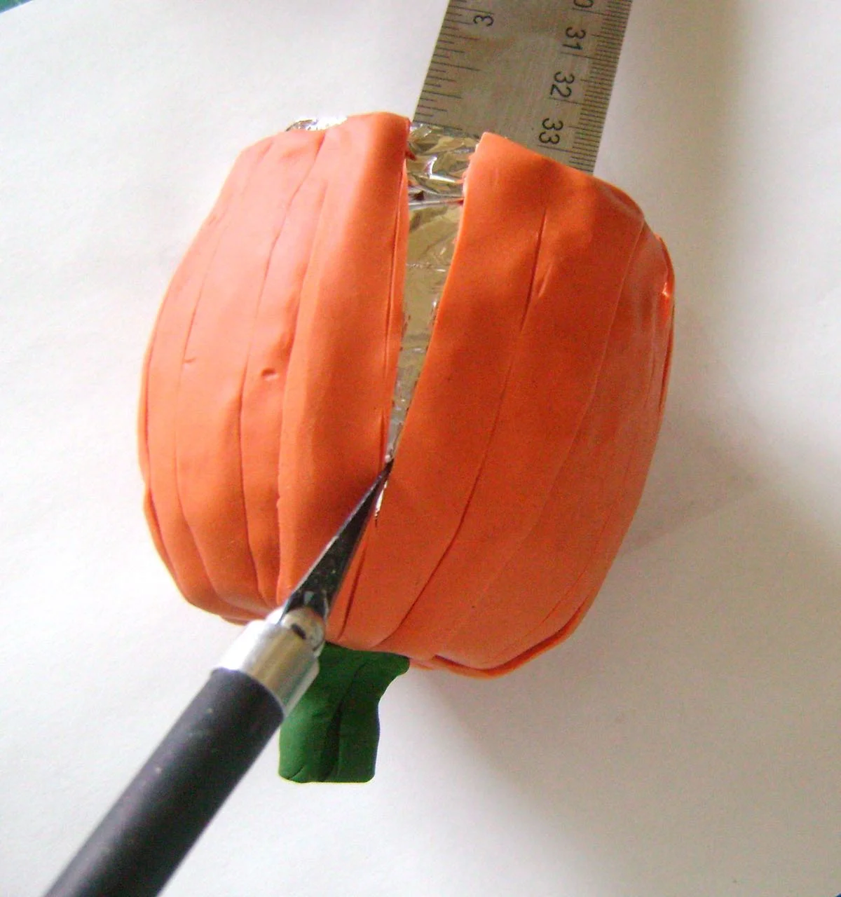 step 11 - Use a craft knife to slice into two indents on opposing sides of the pumpkin from the bottom and stopping at the widest point.