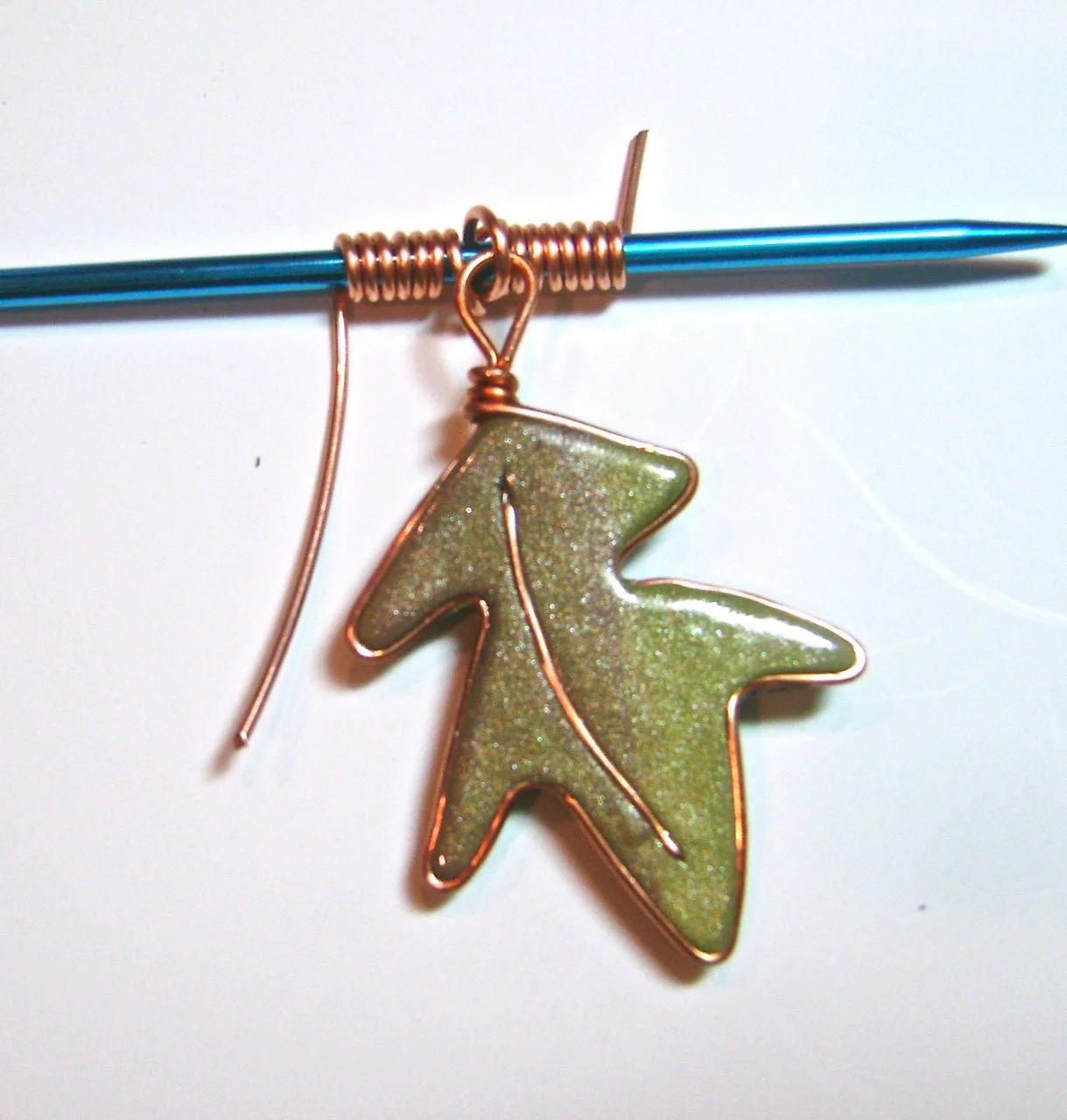 step 11 - Wrap the left and right wire around a knitting needle about seven times. The needle should be large enough to accommodate the leather cord. Cut off the excess wire.