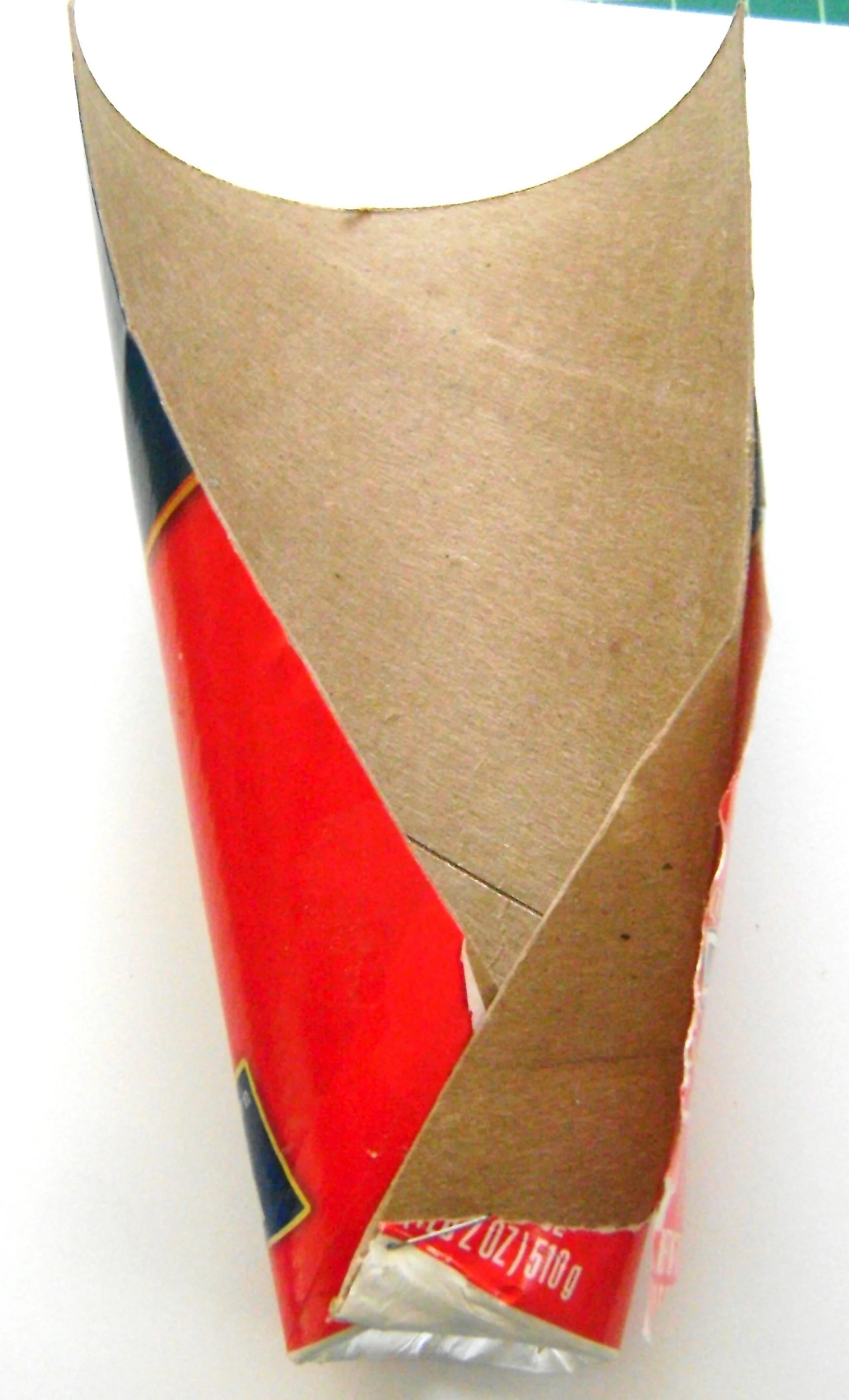 step 1 - Cut a Quaker oats container in half using scissors. Follow the line down each side. Pull off the container bottom. Overlap the bottom edges of the container and staple them together. Peel off the label and smooth aluminum foil over the container. The front should be slightly curved and the backside flat. 