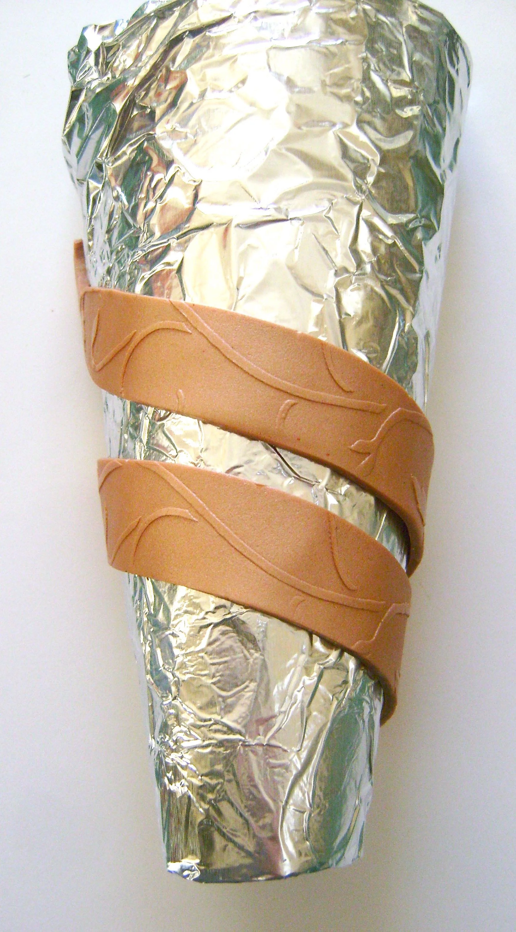 step 3 - Drape the clay strips over the container bringing the flat edges to the center backside. When all three are positioned with equal distance between them and curving across the front of the container, press the back edges together to join them. If they aren't long enough, add another piece of clay where necessary.