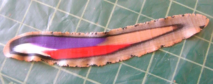 step 7 - Pass the slice through the conditioning machine on #6 setting. This will give you a very thin ribbon with the colors blended. Arc the straight blade to follow the outside edge of the clay and cut off the ragged edges.