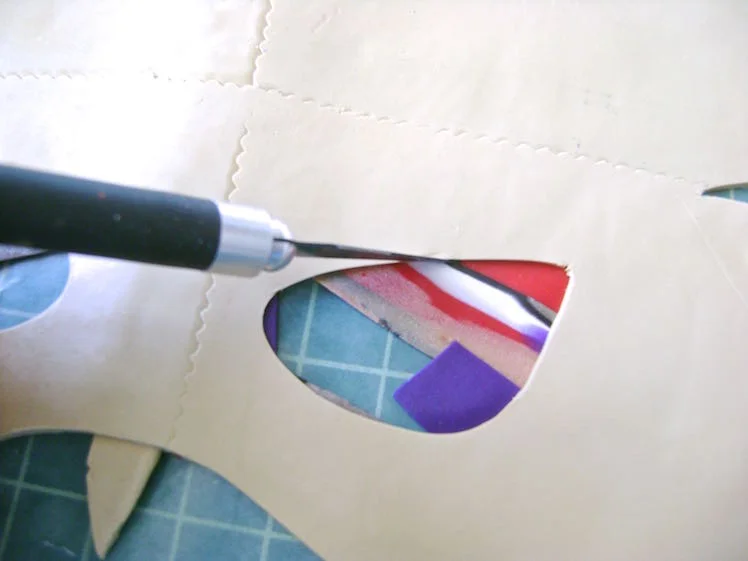 step 13 - When your mask is complete, lay wax paper on top of the project. Flip it over and peel off the original wax paper. With a craft knife, cut out any excess clay blocking the eyes.