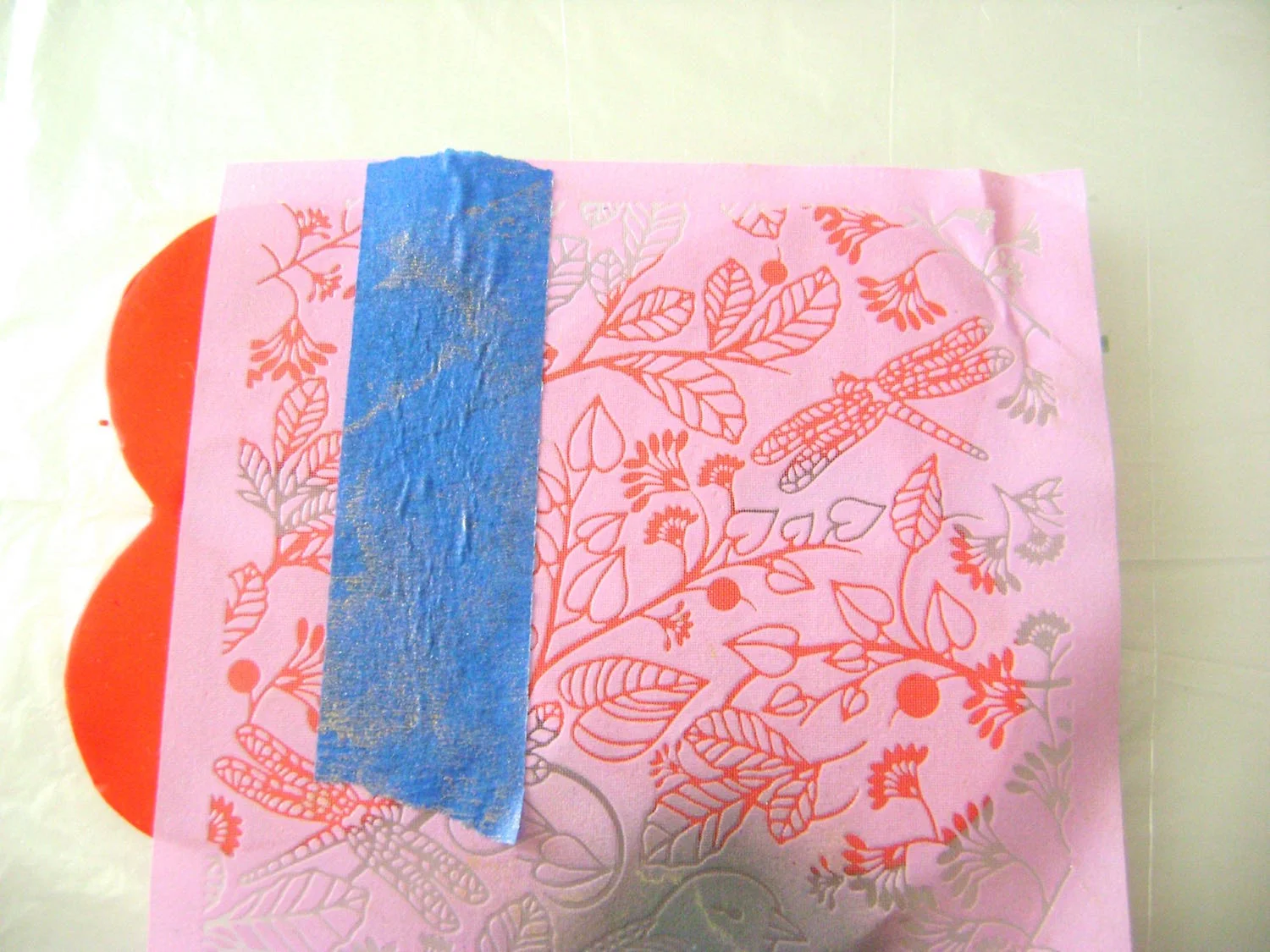 step 4 - Lay the silkscreen shiny side down over the clay. Place tape on the silkscreen to mark the center of the cuff.