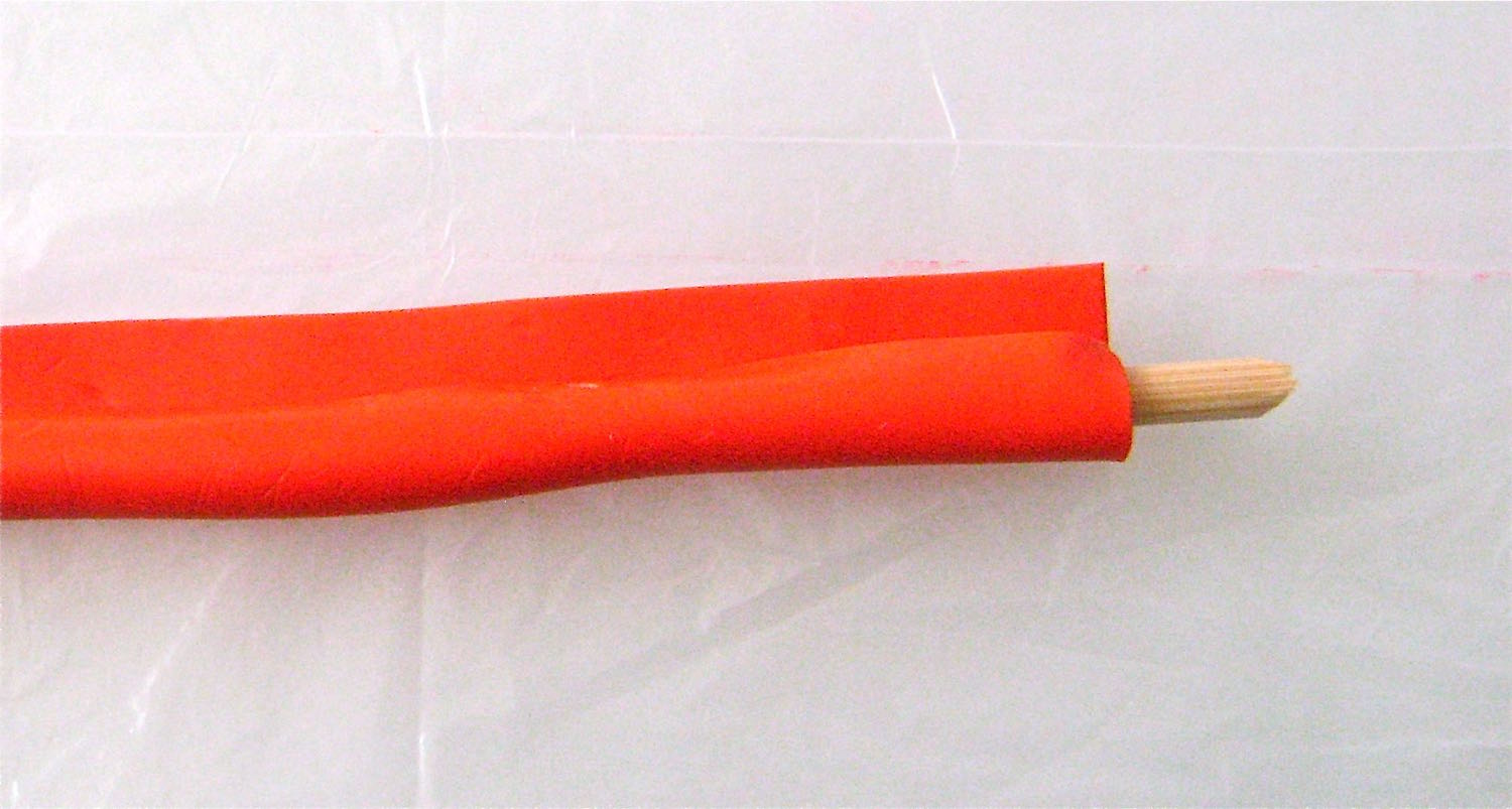 step 7 - Cut a wood skewer to measure 6.50”. Roll out clay on the #6 setting. Cover the skewer with the clay. Roll it back and forth on the work surface until the seam disappears. Use your fingers to wrap and smooth the clay around the pointy end.