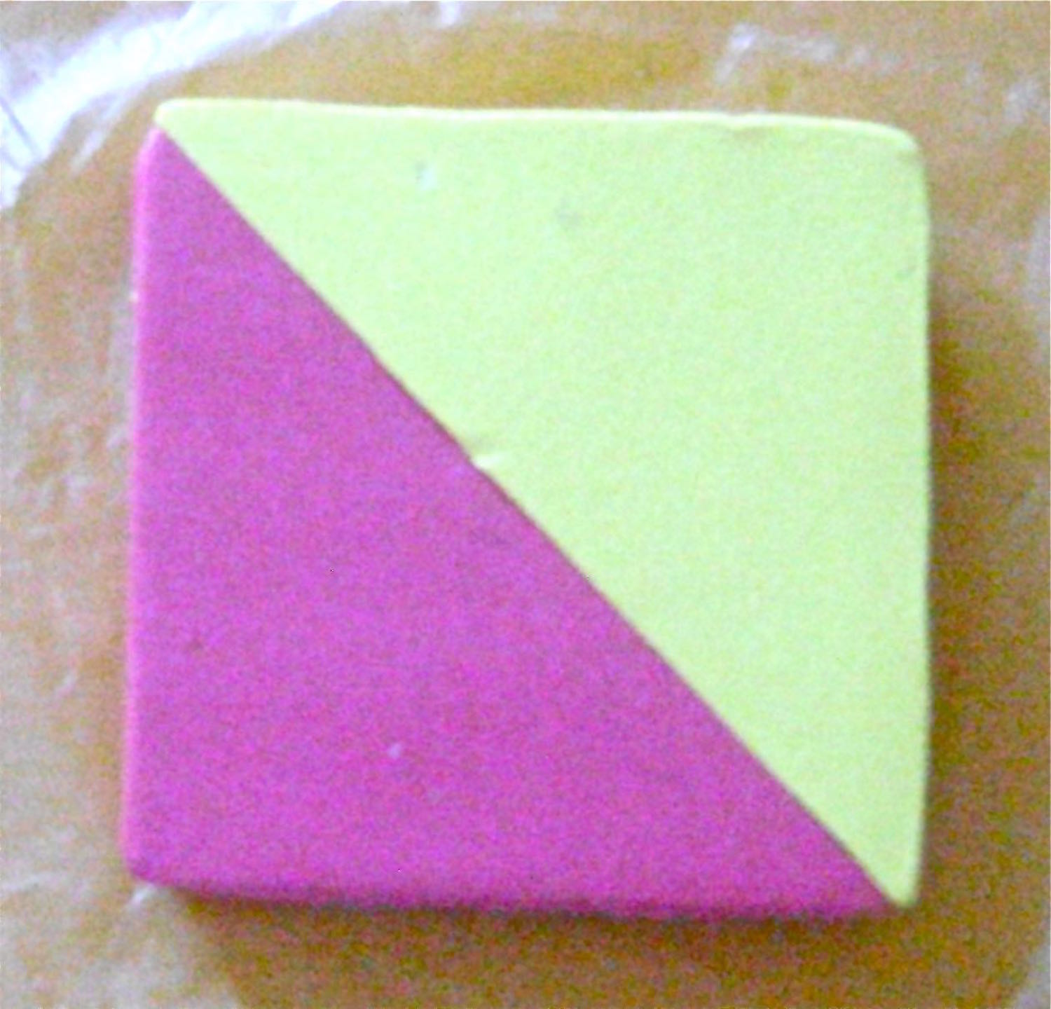 step 2 - Stack the two pink triangles with all edges aligned. Do the same with the yellow. Press them together to attach them at the diagonal seam.