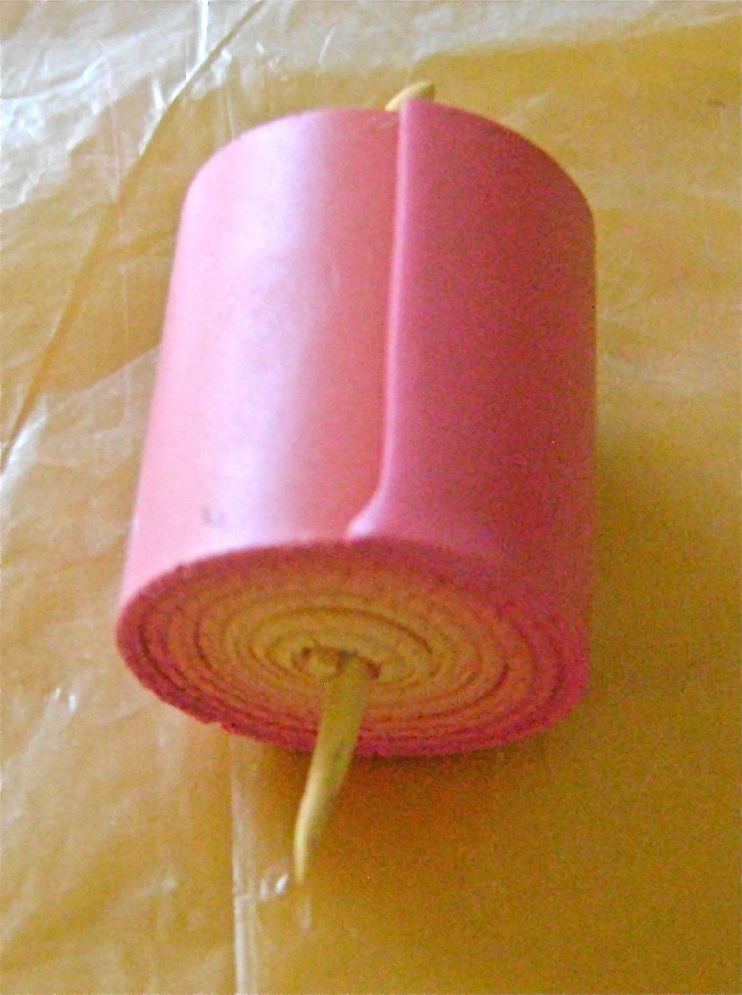 step 6 - Use the snake to help you roll the clay into a snug jellyroll. Blend the seam of the pink edge into the tube.