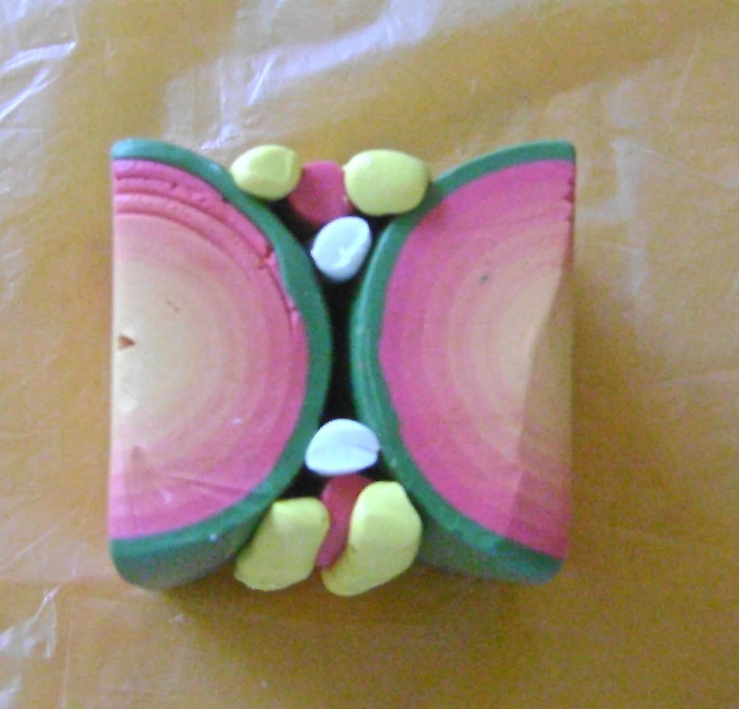 step 10 - Roll four thin snakes of yellow, two of pink, and two of white. Use the snakes to fill in the empty space between the two jellyroll halves.
