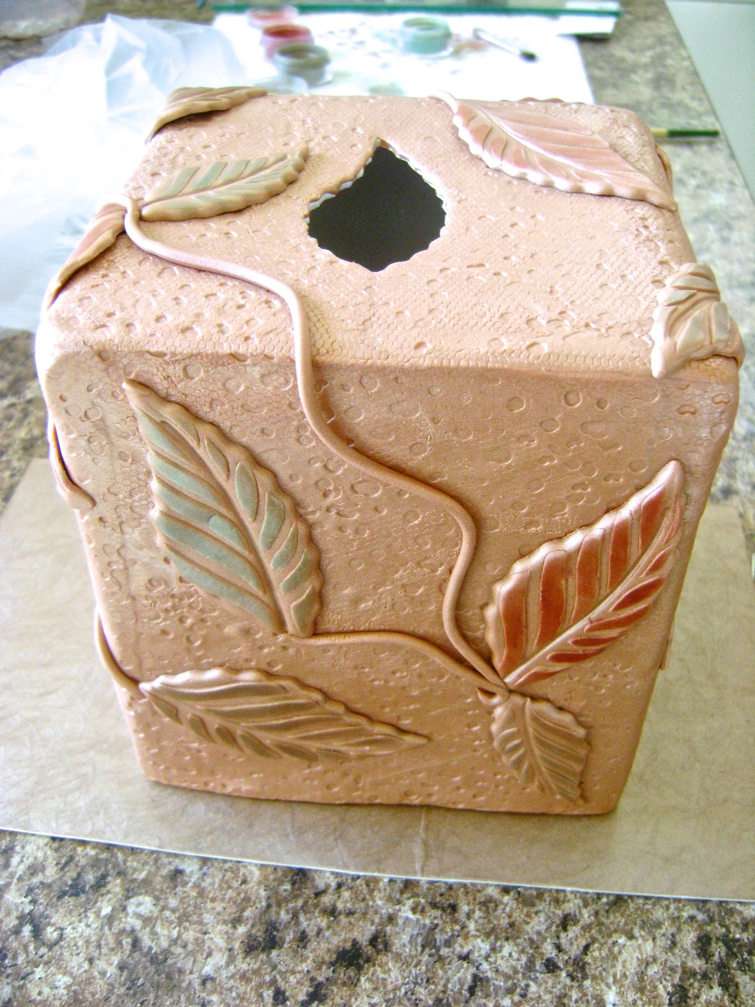 step 11 - Arrange the leavesand vines on the clay box, pressing them gently enough not to distort the design.