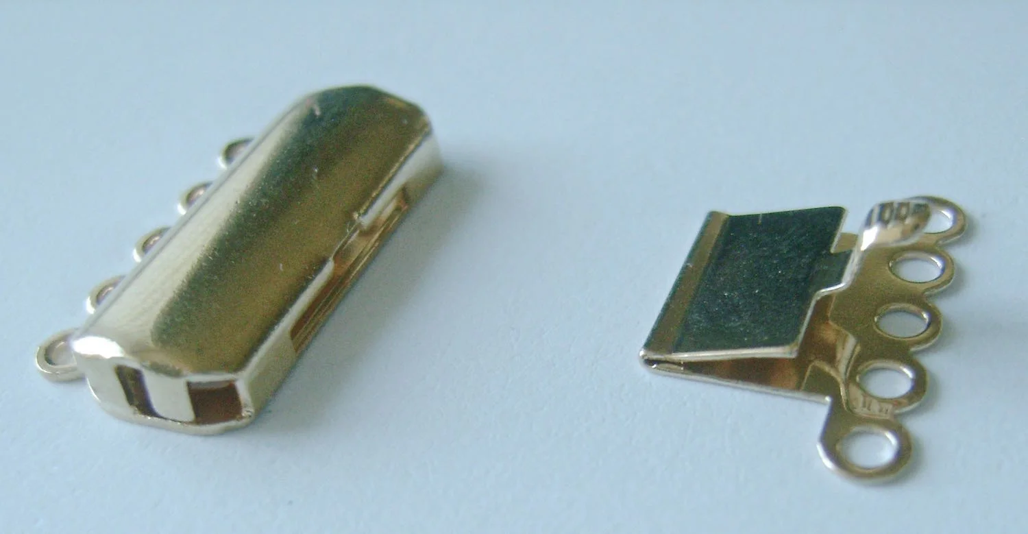 step 11 - The tab insert portion of the clasp must have free movement to work properly. If there is thick clay beneath it, you won’t be able to press the tab down for release. It needs a special clay extension to attach it to the bracelet. 