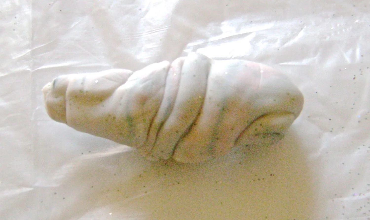 step 6 - Roll the clay into a stubby tube in your hands. Twist it then squash it flat. Twist again then flatten with your hands. Overworking the clay will result in less individual color definition.