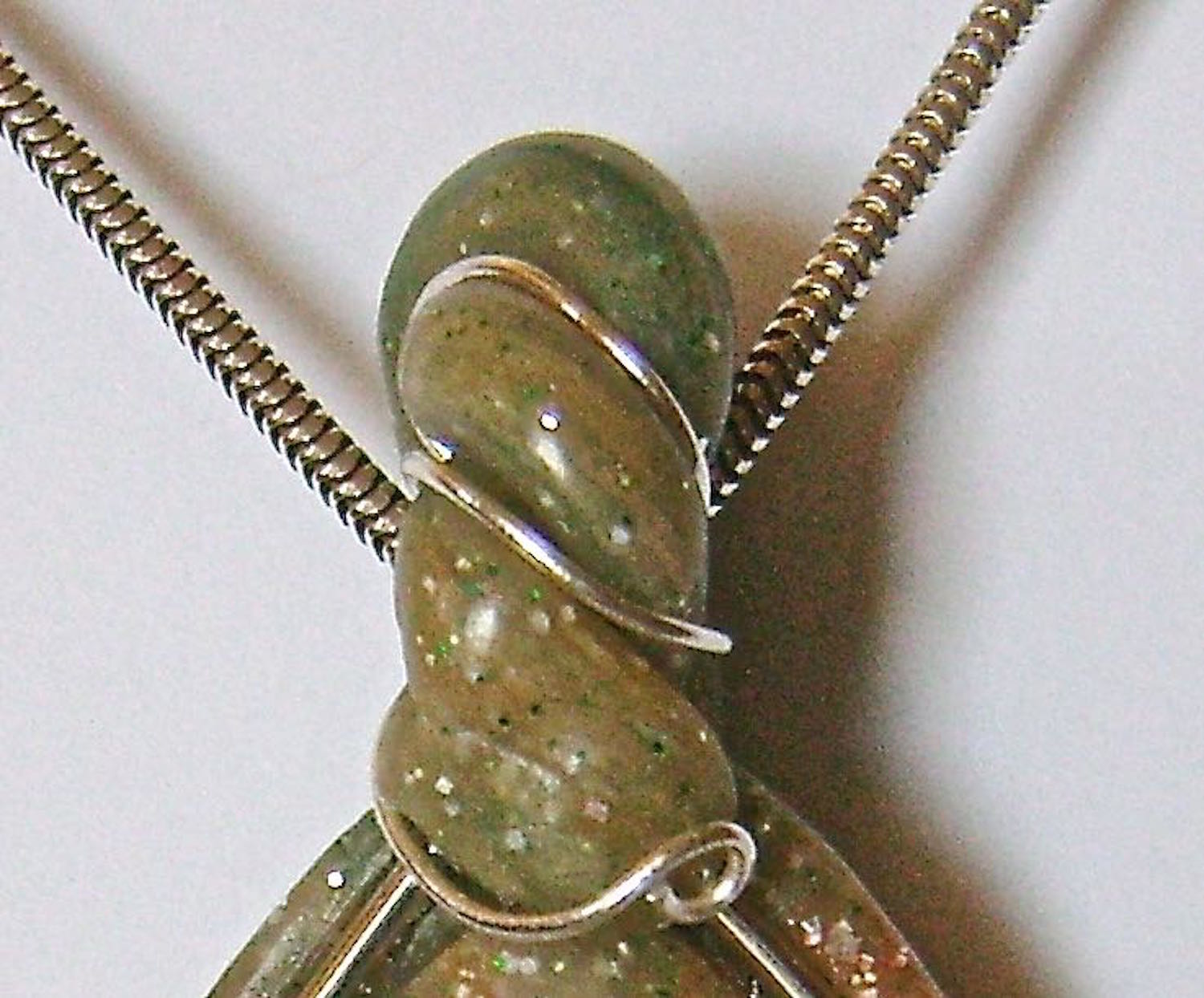 step 17 - Wrap the 22 gauge wire into the folds of the bail. Create small spirals on the front and back ends of the wire with round nose pliers.