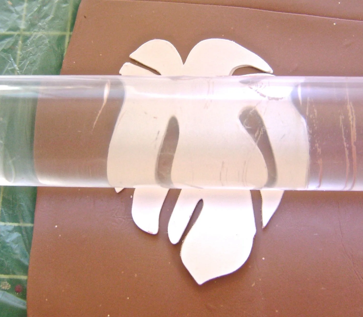 step 6 - Place the paper image powder side down onto the scrap clay which will become your texture sheet. Feed both into the conditioning machine on the widest setting or use an acrylic roller to press the image into the clay. Three layers of card stock will produce a very defined impression. 