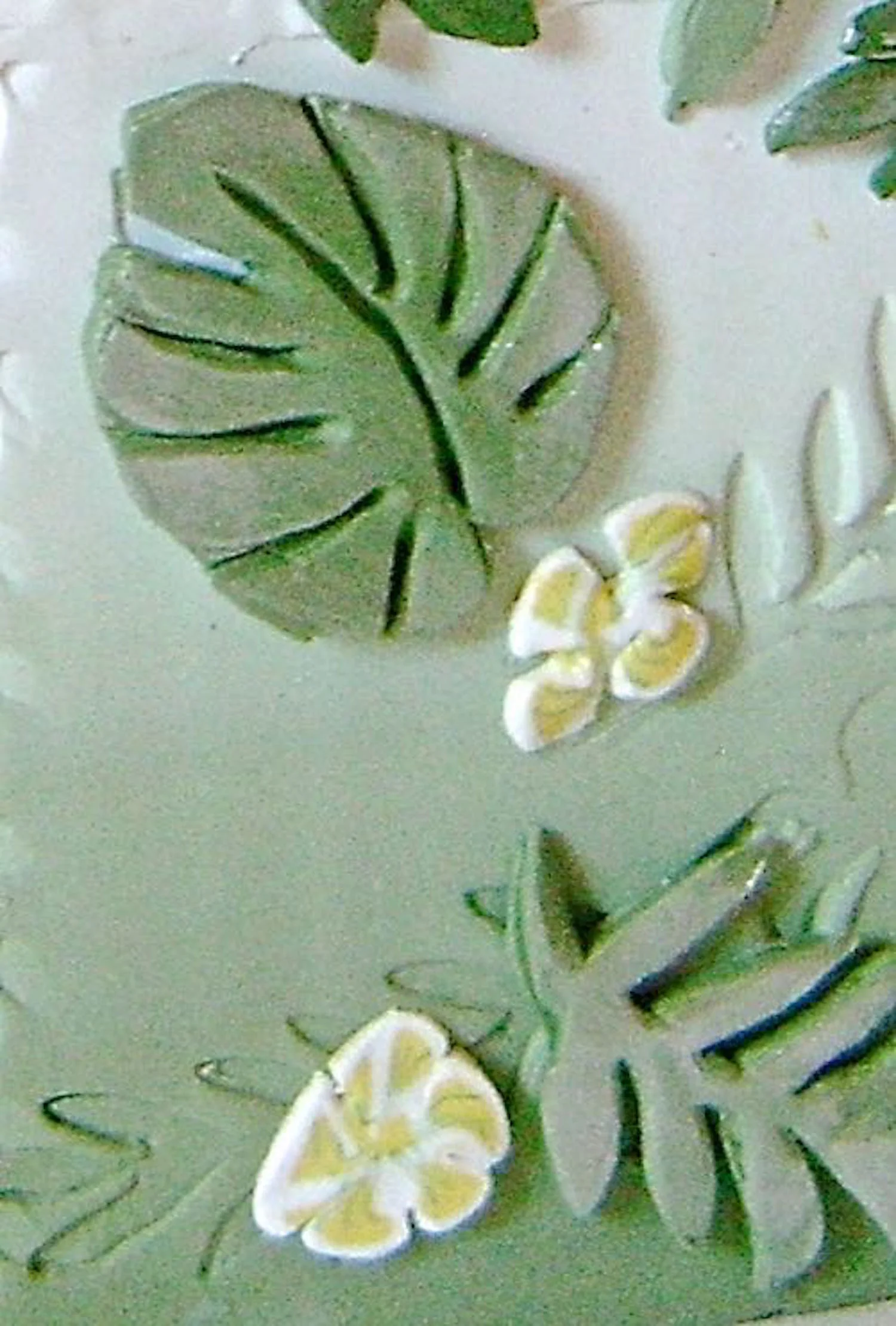 step 12 - Use the texture sheets you created in step six to cut leaves from scraps of the blended clay. Press them onto the clay covered box as desired. Apply mica powder to the outer edges of the leaves, rubbing and blending it with your finger.