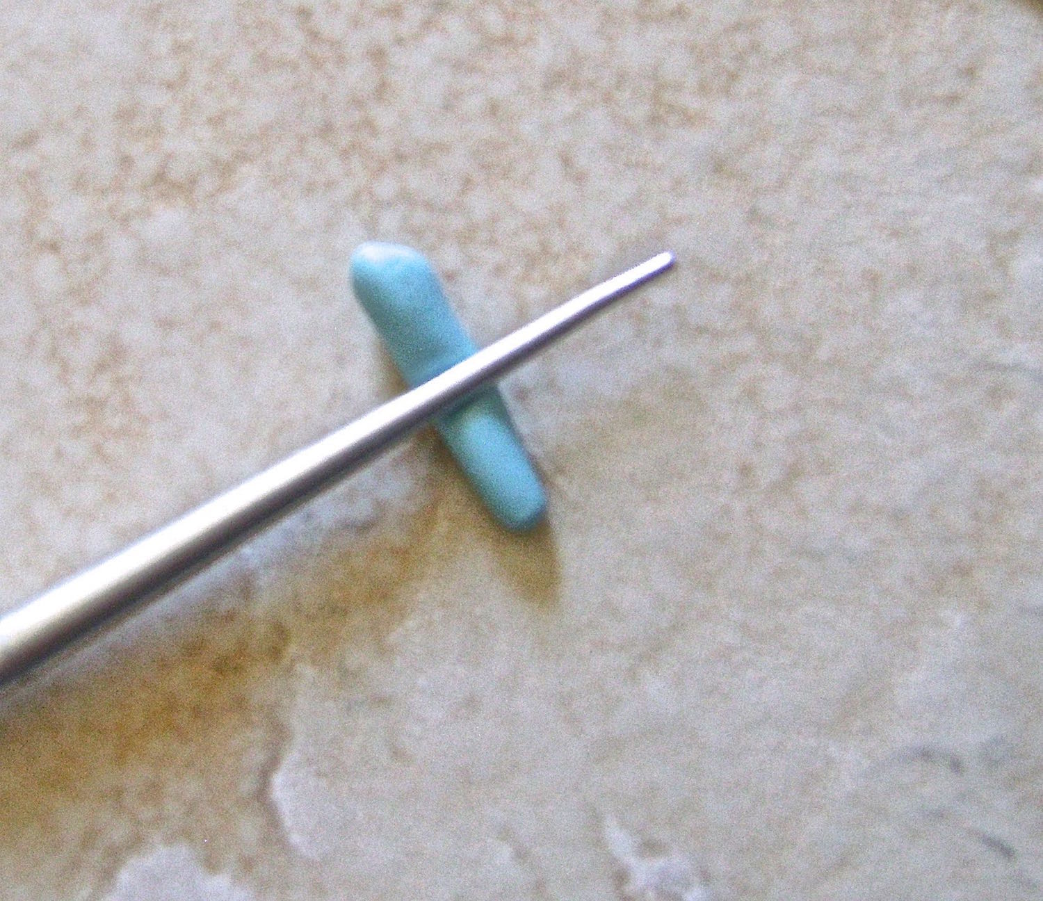 step 6 - In your palms, roll out six pieces of blue clay for the fingers. Cut them at different lengths. Press a thin knitting needle or an Etch N Pearl tool across each.