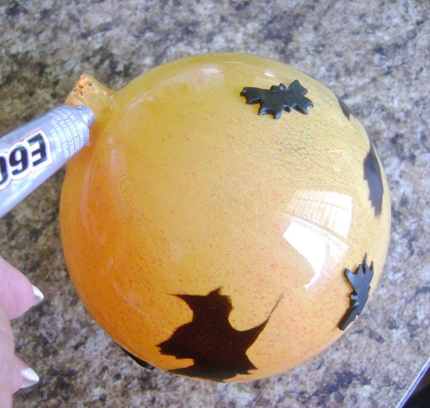 step 15 - After the yellow paint has dried, apply E6000 to the neck opening of the ornament. Press the hat onto the opening.