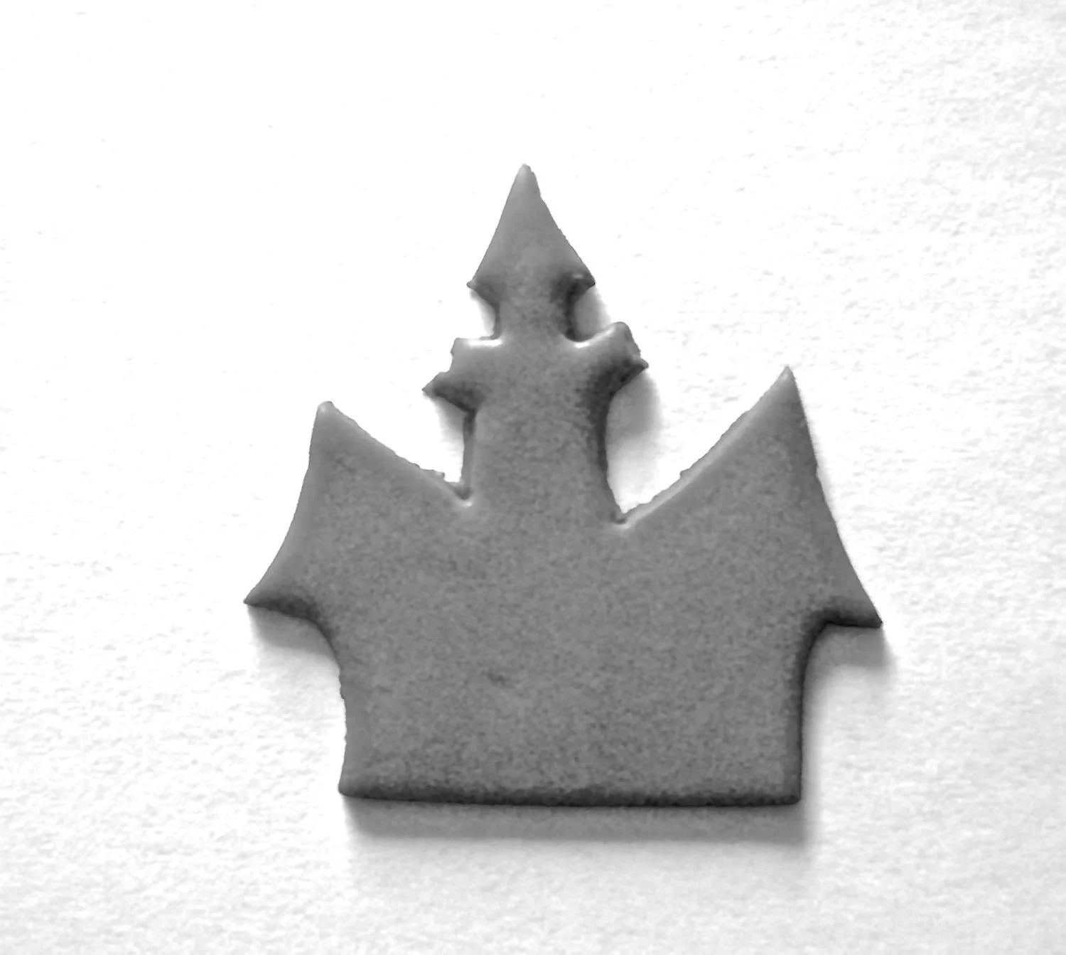 step 3 - Print out the haunted house stencil on card stock. Use a craft knife to cut out the image. Place the card stock on black clay and cut it out with the knife. Add bits of orange clay for doors and windows.