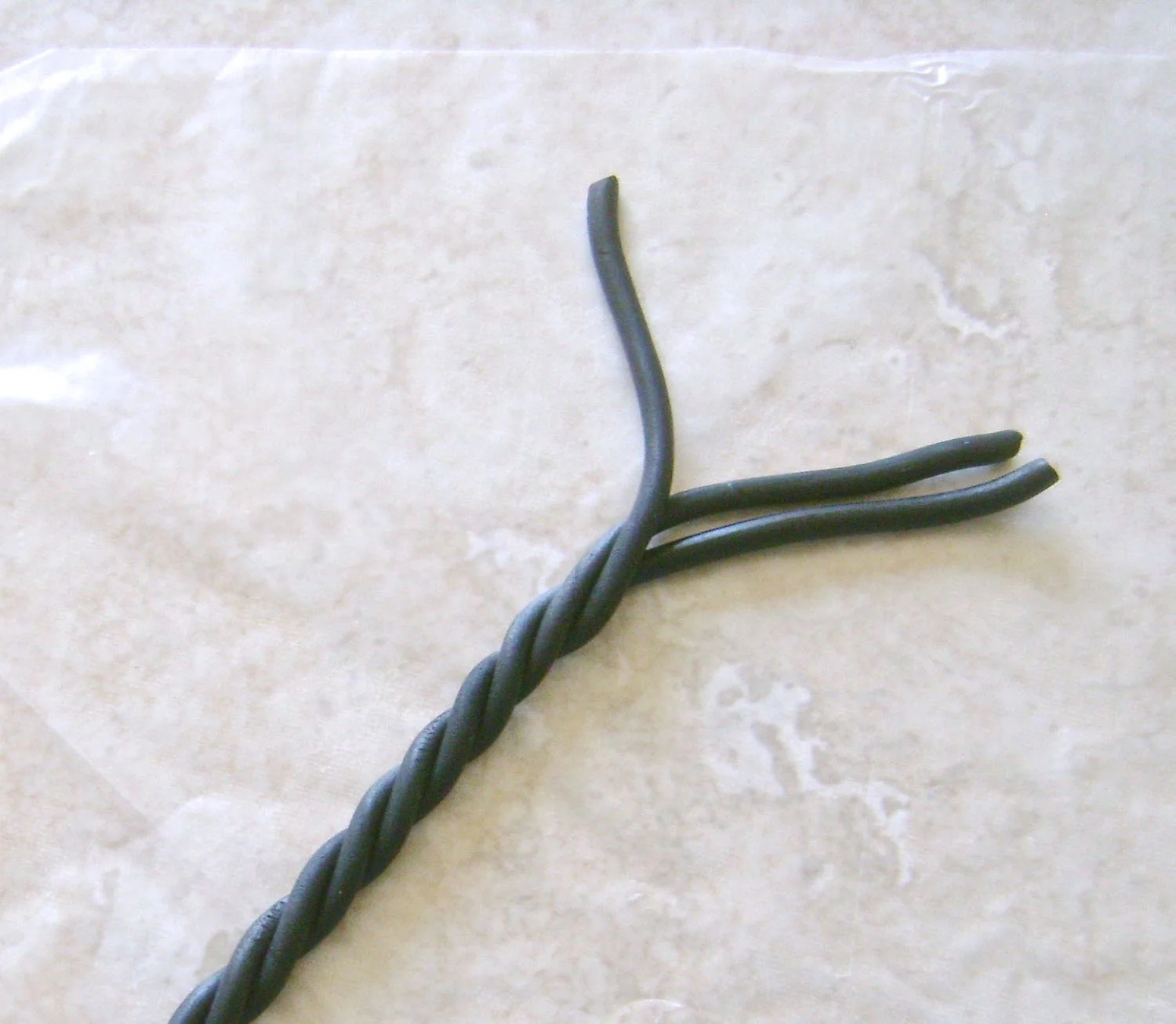 step 7 - Use an extruder or roll thin strips of clay with your hands across the work surface. Create seven tubes for the tree. Twist three tube around each other leaving about 1.50” loose on each end.