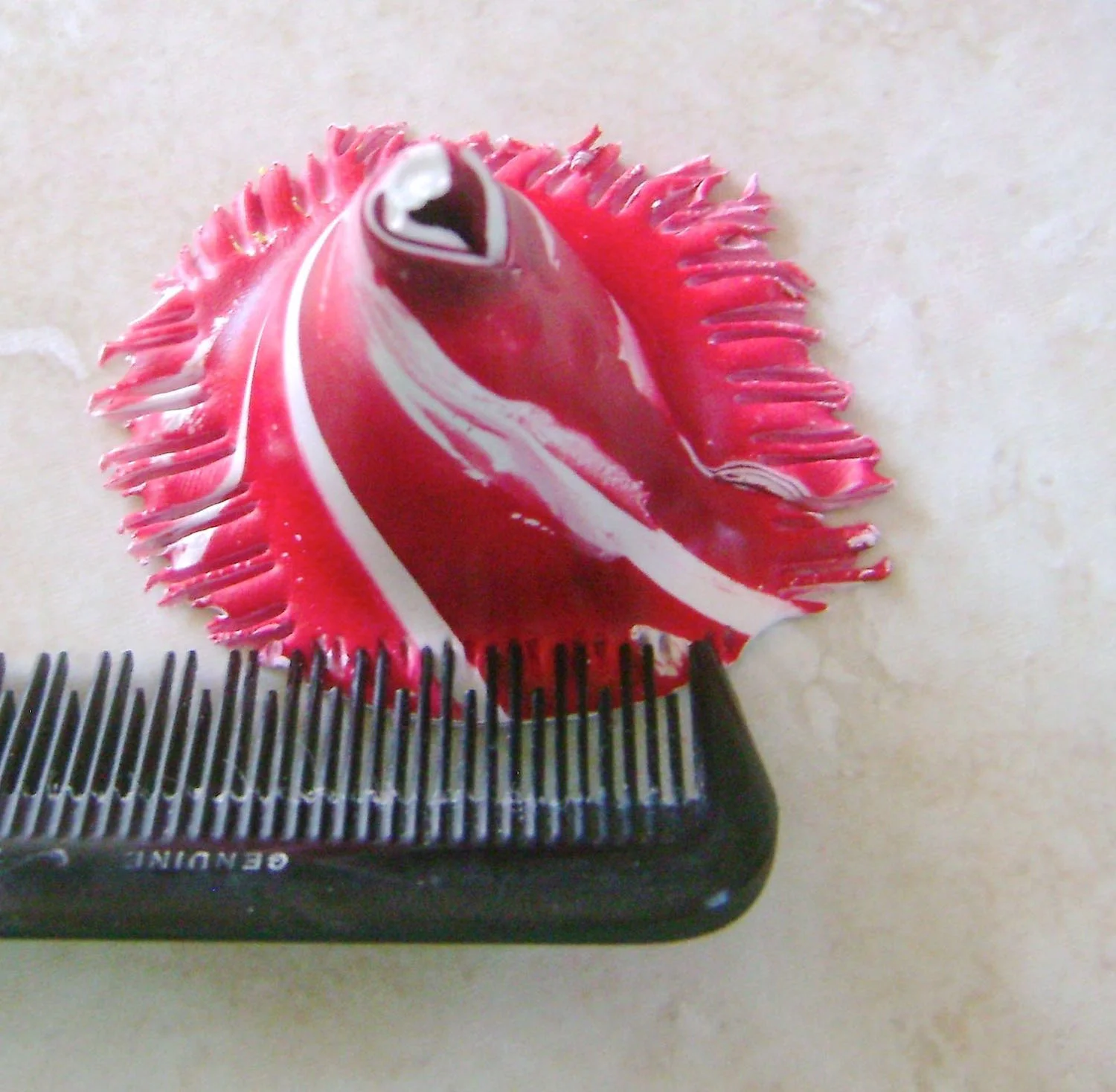step 5 - Set the clay on the work surface. Pinch the bottom edge to flare it out. Press the teeth of a comb against the clay and pull to create a ragged hemline.