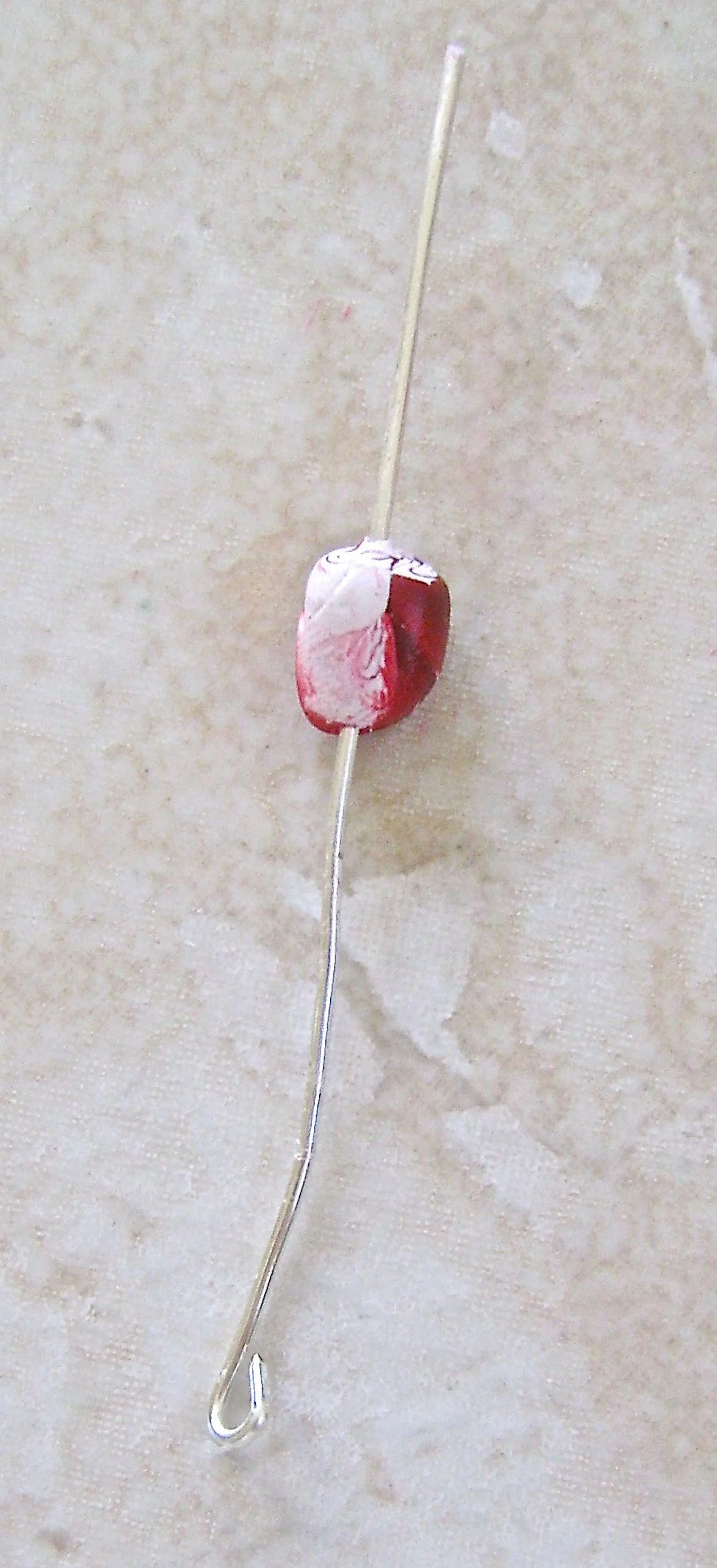 step 6 - Cut a piece of wire to measure 3” long. Make a small loop on one end. Roll out a clump of clay in your hands into a teardrop shape. Slip the blunt end of the wire through the center of the clay and coat the top portion of the clay and 1/4” of the wire with Liquid Polymer. Slide the wire up into the clay cone.