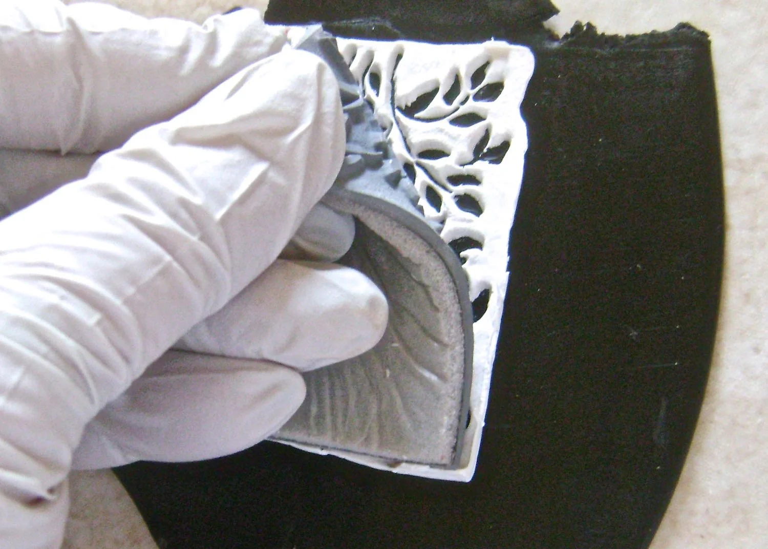 step 3 - Slowly peel the rubber stamp away from the black clay with a rolling motion. If you see white clay stuck in the stamp, press it back down and push on it. It will stick to the black clay.
