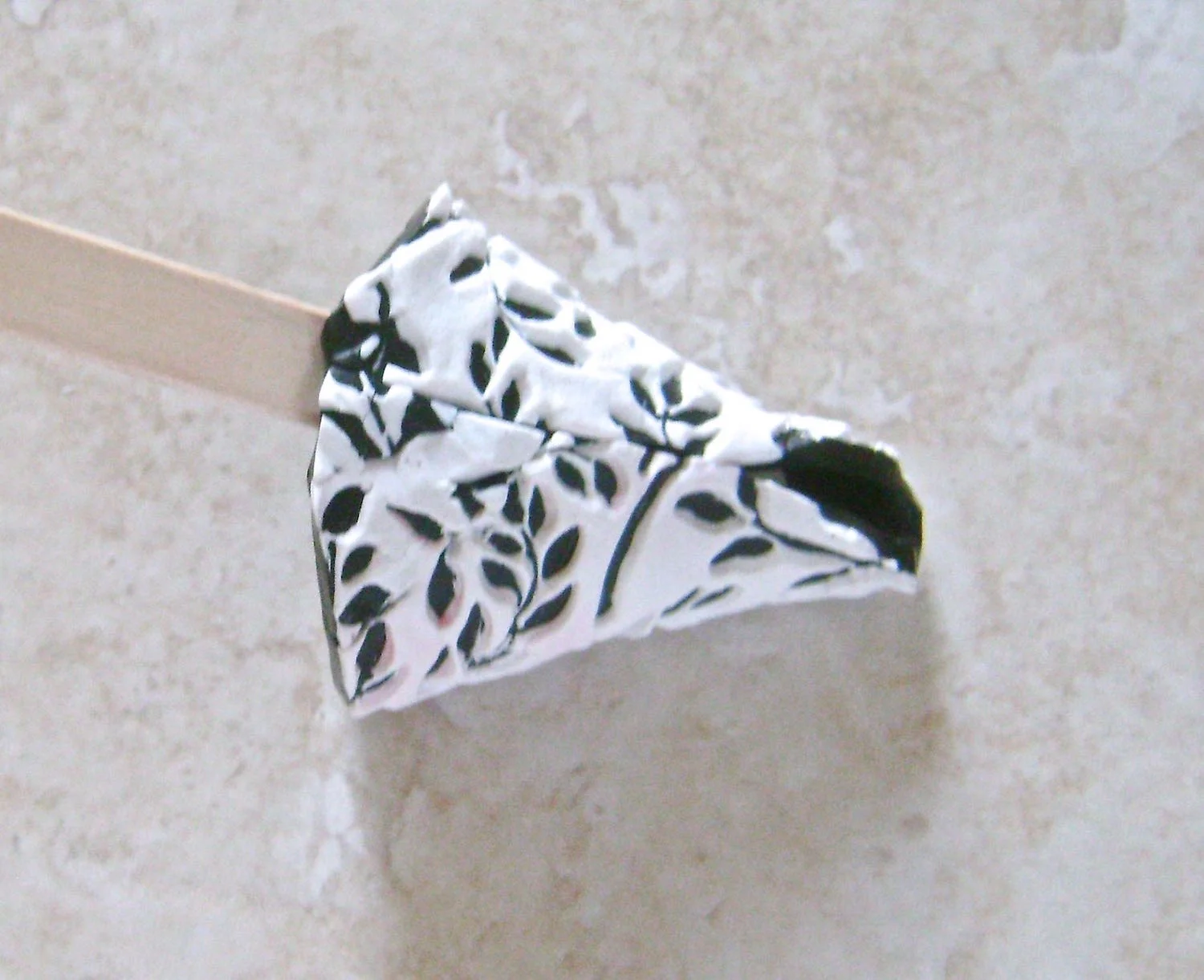 step 6 - Place a craft stick under the straight edges of the clay cone and pinch the edges together. Blend them using the stick as support.