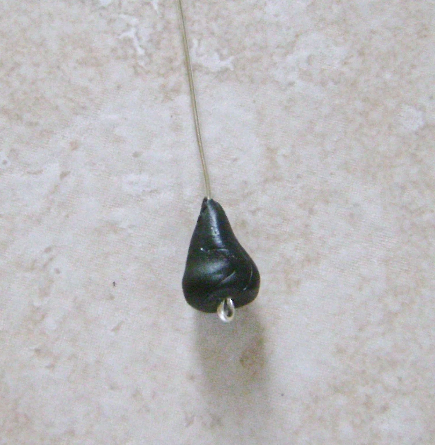 step 7 - Cut a piece of wire to measure 3” long. Make a small loop on one end. Roll out a clump of clay in your hands into a teardrop shape. Slip the blunt end of the wire through the center of the clay and coat the top portion of the clay and 1/4” of the wire with Liquid Polymer. Slide the wire up into the clay cone.