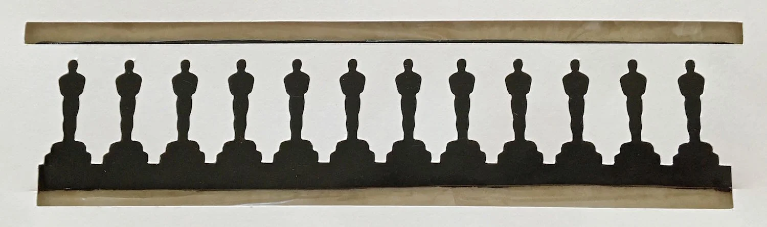 step 3 - Set the clay on bakers plastic or parchment paper. Use an acrylic roller to press the stencil image into the clay. The clay will rise to the surface of the card stock.