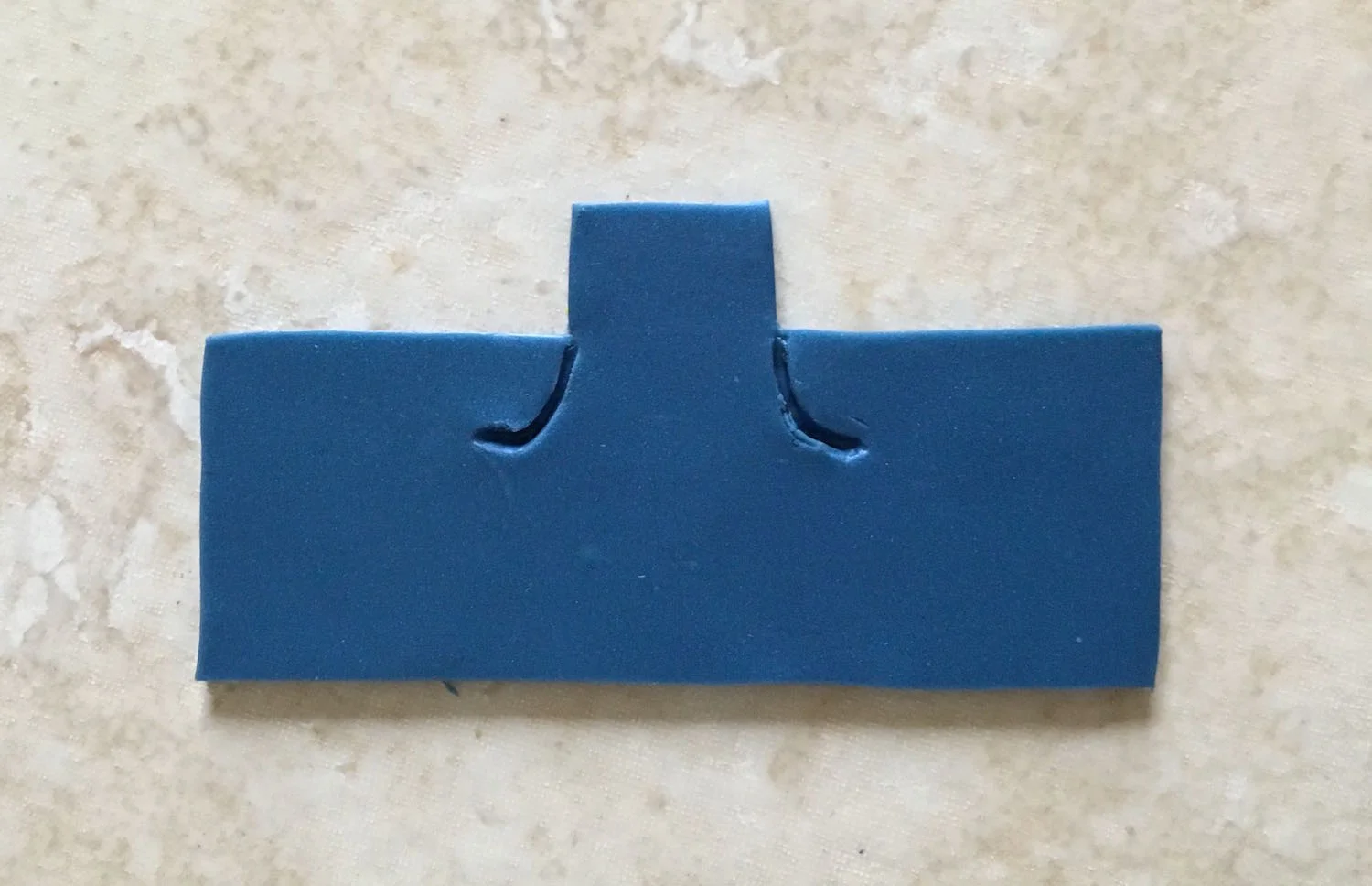 step 9 - Mix blue and a tiny bit of black clay for the denim color. Cut two overall pieces that will reach half way around the body. Create indentations for the pockets on the front half.
