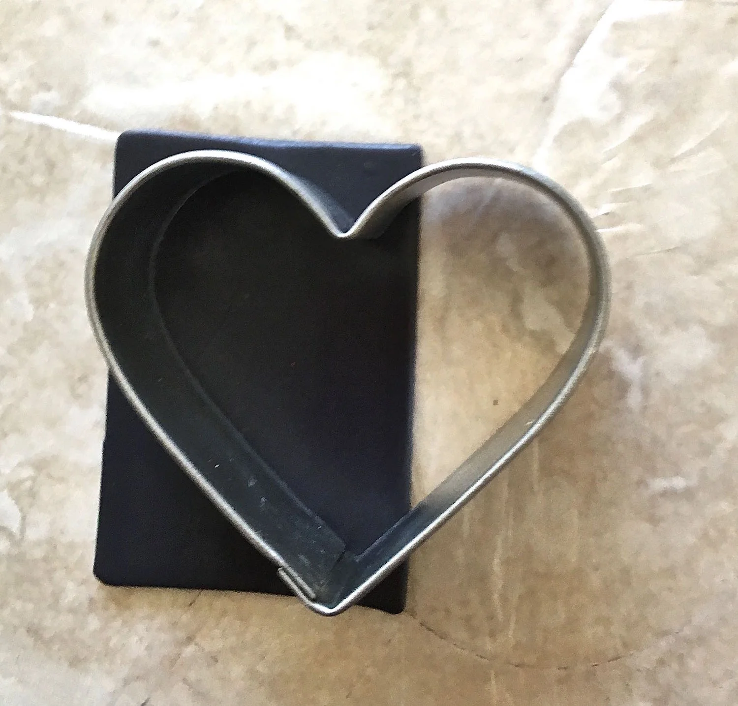 step 2 - Create navy blue clay by mixing black with purple. Add bits of black a little at a time blending after each addition until the color you want is achieved. Roll the clay on the # 3 setting of the conditioning machine. Cut a rectangular piece of navy blue clay slightly larger than half of the large heart cutter.
