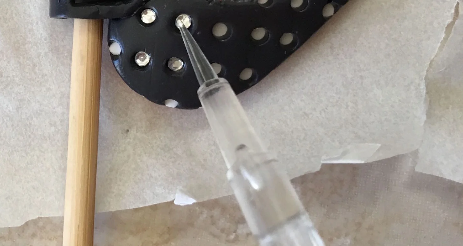 step 16 - Place 10ss hot fix rhinestones in all the holes of the navy blue clay.