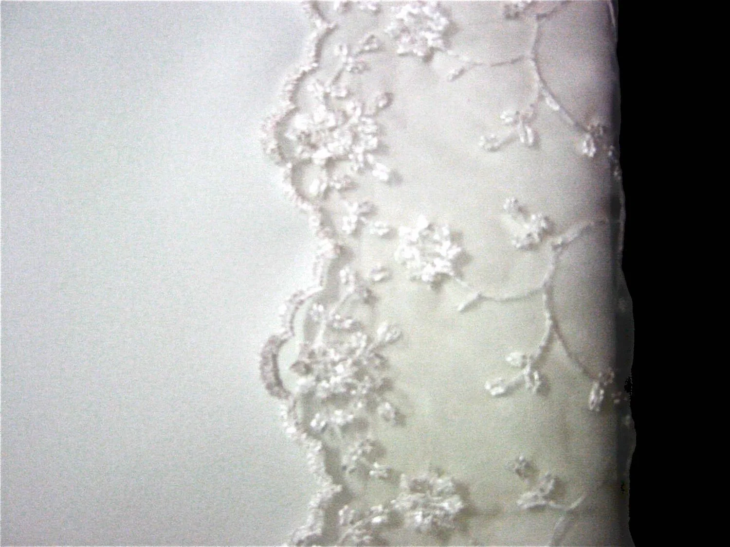 This sheer lace fabric was applied following the instructions for pillow cases with decorative borders. The border edge stitching does not follow the scallop edging. Itruns on top of the lace.