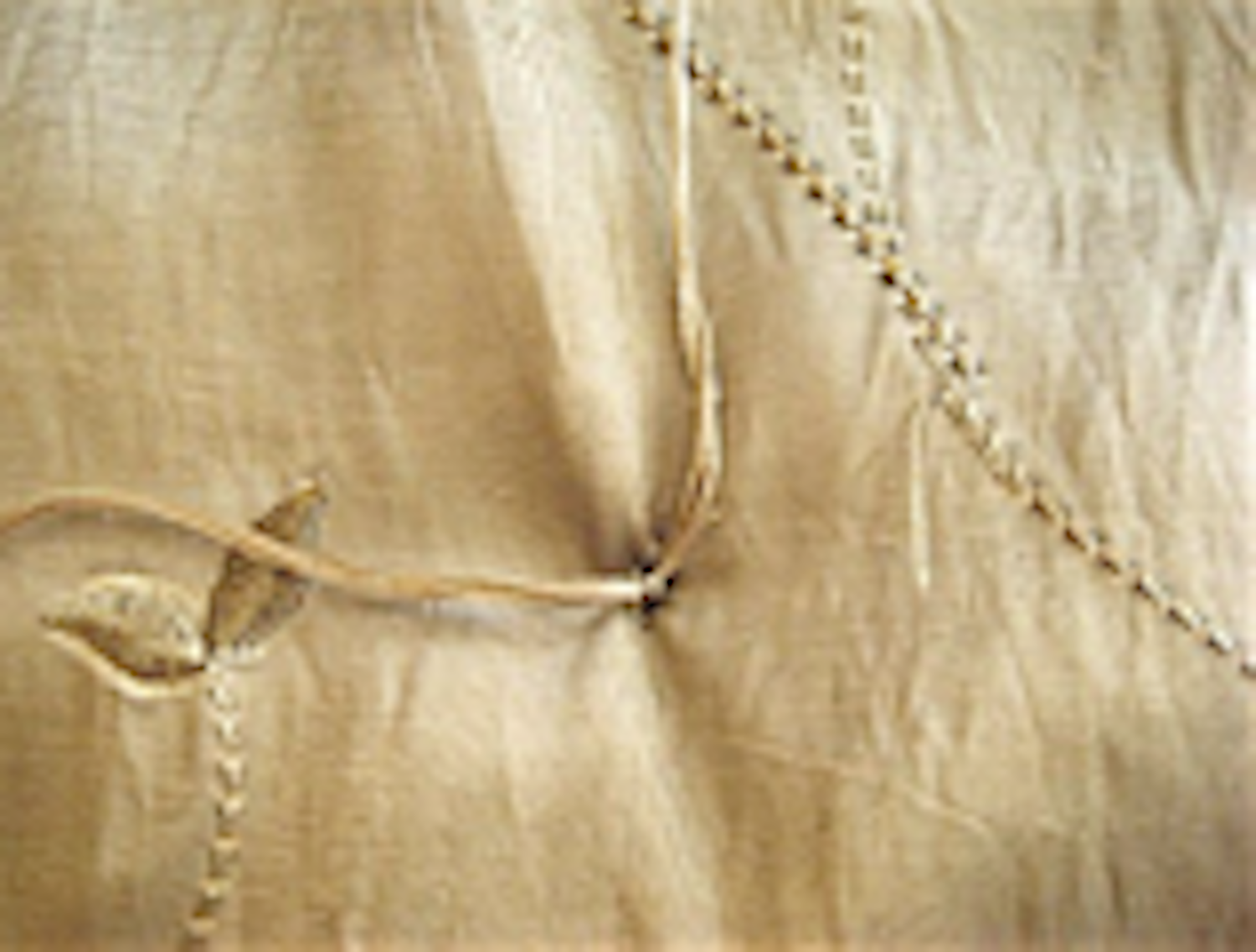 step 12 - Tie a triple knot in the two pieces of floss on the underside. Cut off excess floss close to the knot. Tuft at every marker of the comforter working from the center out, until all tufts are completed.