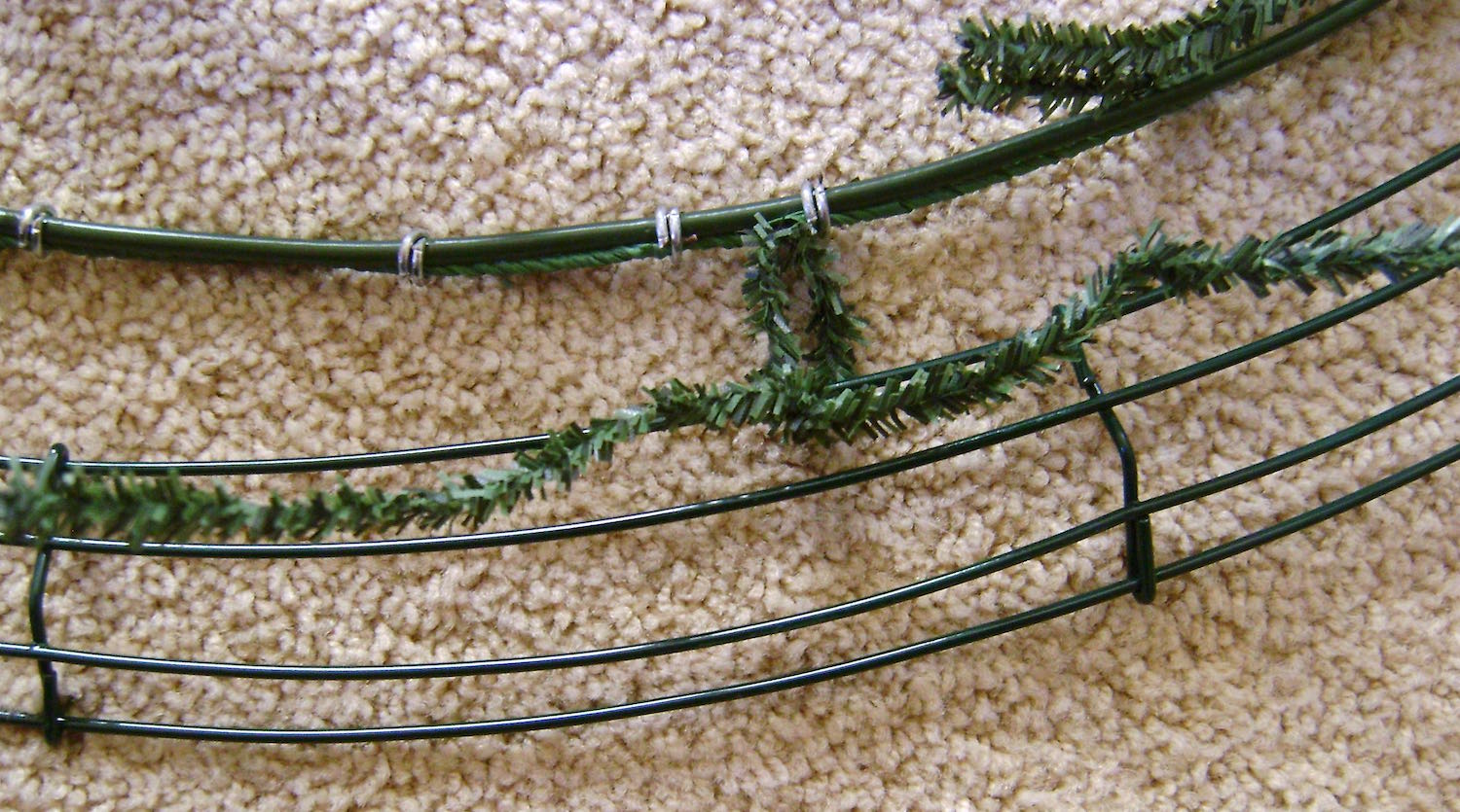 step 2 - Attach the wreaths to each other using the twist ties on the outer circle. Attach the top and bottom centers first, followed by the sides. Be sure the spacing between the wreaths is equal all around.