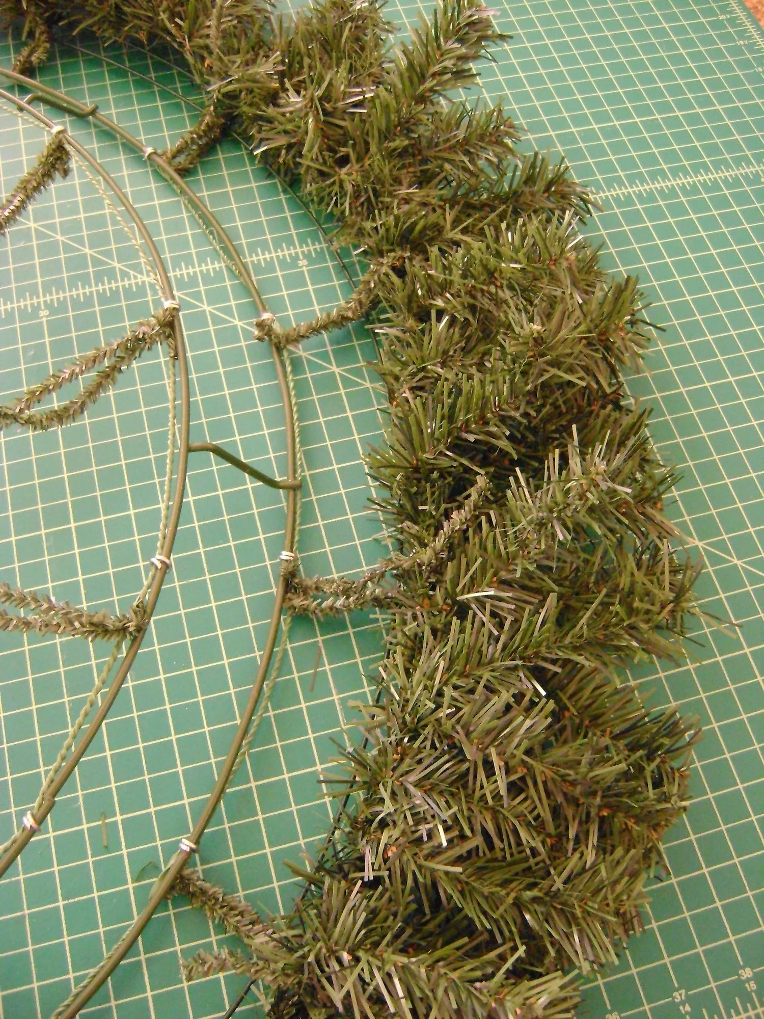 step 5 - As you attach the garland, bend all the stems to the outside which will give the wreath a larger diameter.