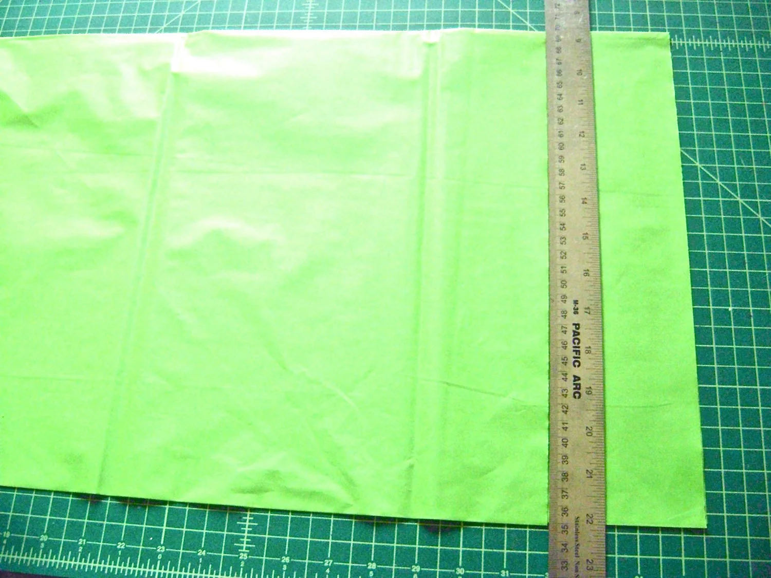 step 3 - Remove the table cloth from the package and unfold it lengthwise. Do not open the width, leave it folded so you can cut several strips at once. Cut 3.50” wide strips across the length. You will need three of the green, yellow, and pink. Cut 21 to 24 of the white. How tightly you gather the strips will determine how many you will need. The individual strips will each measure3.5” x 54”. 