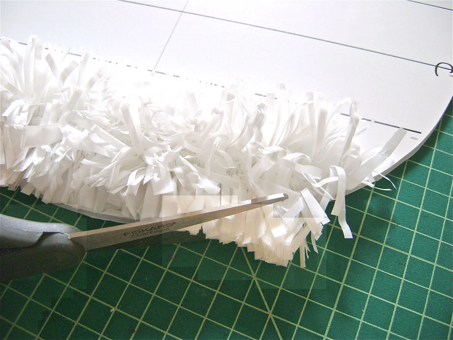 step 9 - When the egg is completely covered use scissors to shape the top and bottom curves, eliminating sharp angles. Use a skewer to poke a whole through the top center of the egg and attach a ribbon.